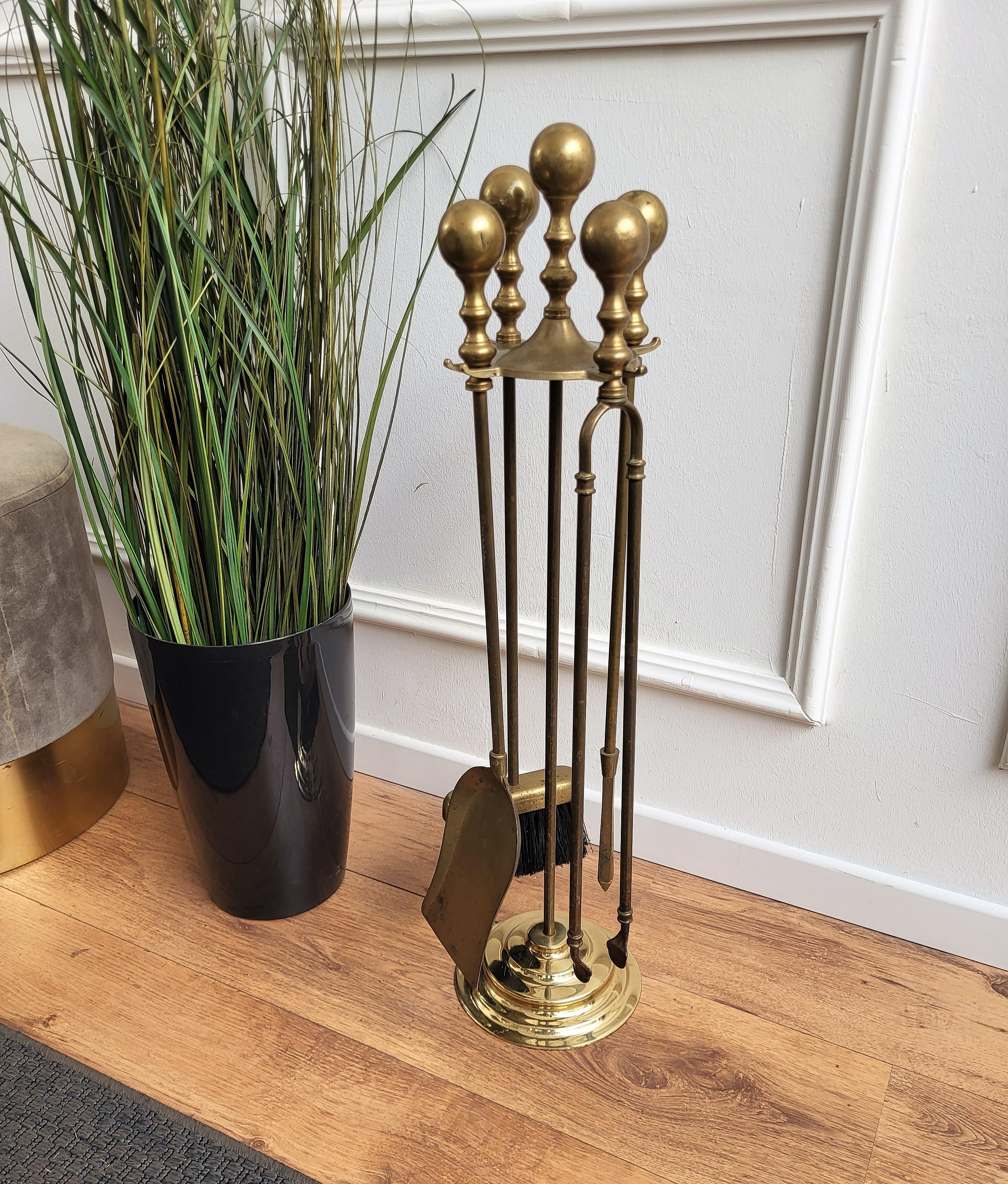 Italian brass four-piece fire tool set with stand. The set consists of a poker, a shovel and a pair of tongs, each with an ornate handle such as the stand. 

