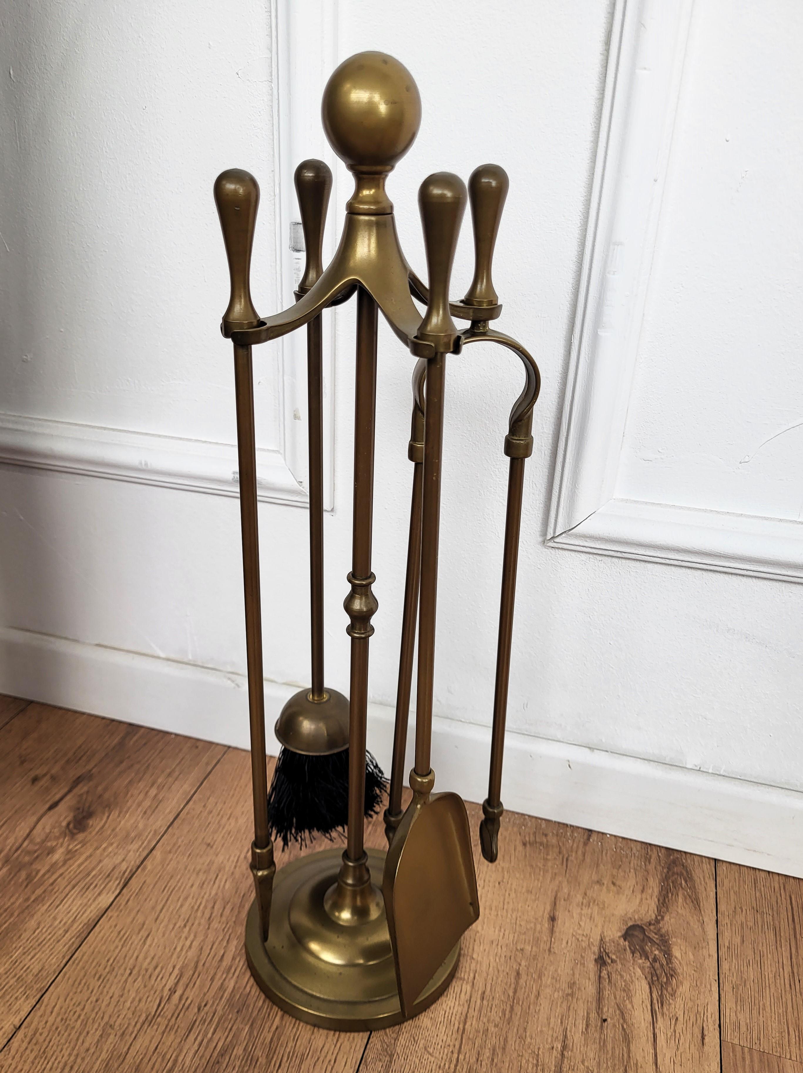 Italian brass four-piece fire tool set with stand. The set consists of a poker, a shovel and a pair of tongs, each with an ornate handle such as the stand. 

