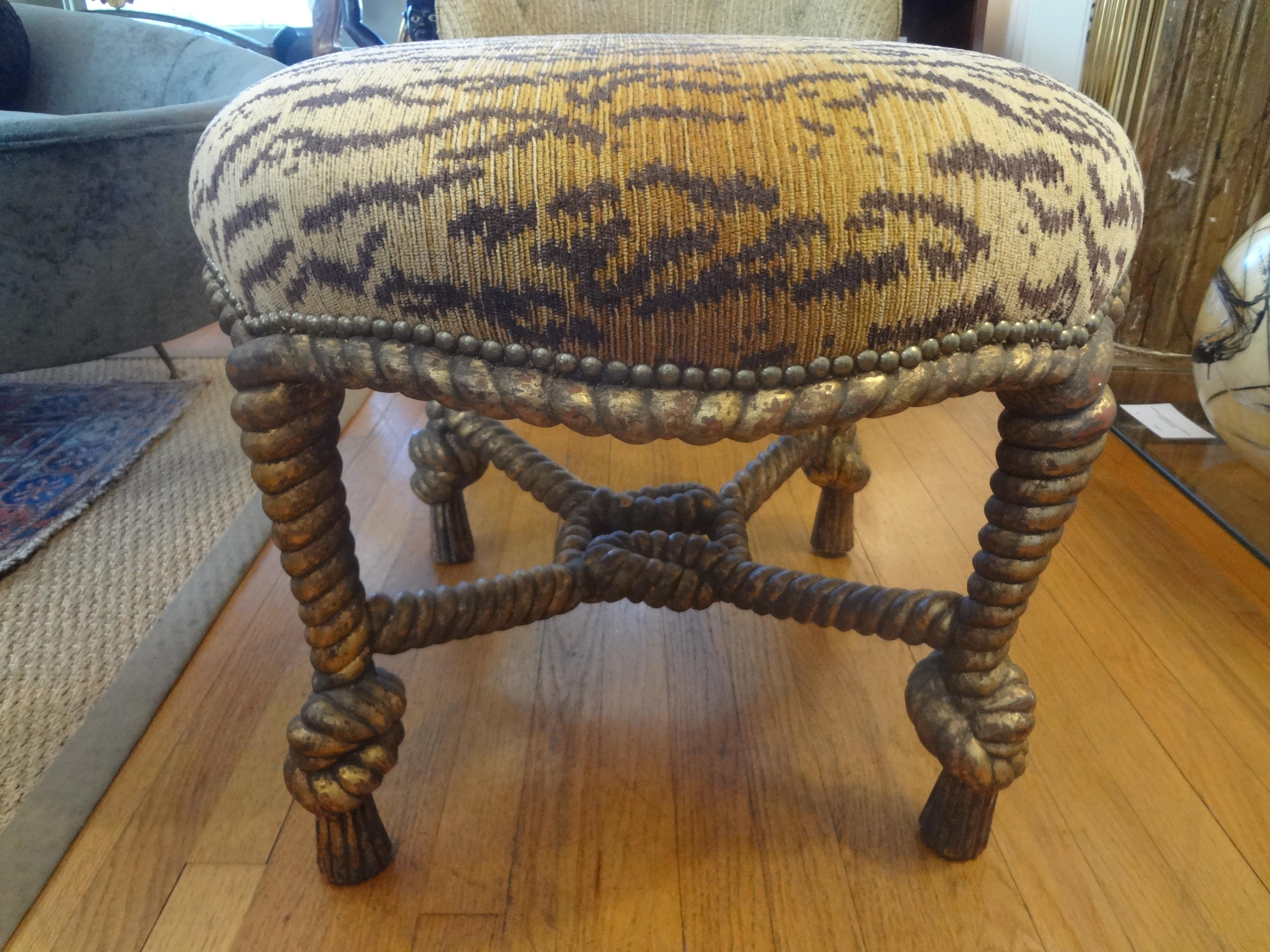 Stunning Italian A.M.E. Fournier style, Louis XVI style, or Napoleon III style carved giltwood knotted rope and tassel ottoman. This large and comfortable ottoman, stool, bench or tabouret is currently upholstered in leopard chenille fabric with