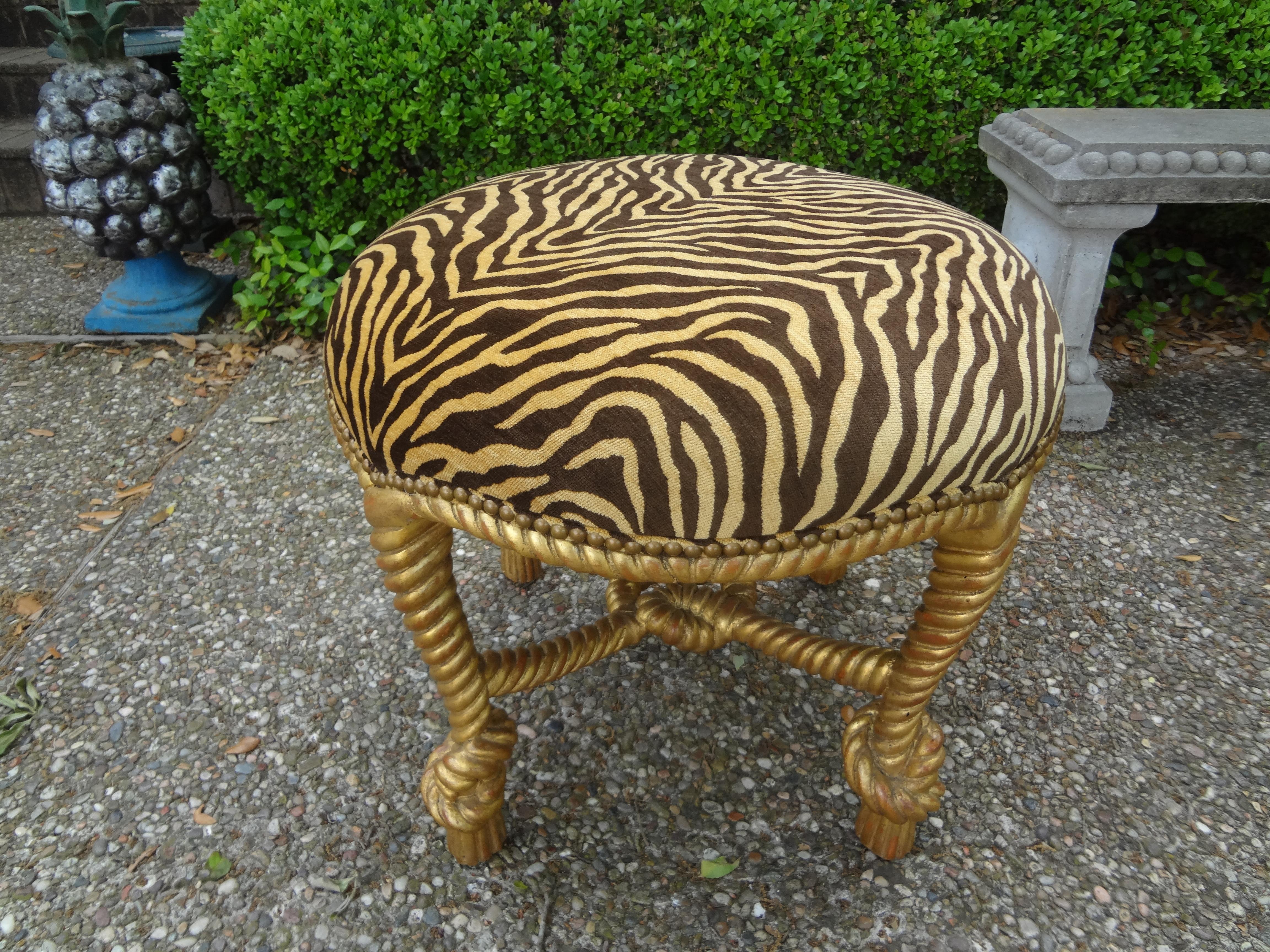Stunning Italian A.M.E. Fournier style, Louis XVI style, or Napoleon III style carved giltwood knotted rope and tassel ottoman. This large and comfortable ottoman, stool, bench or tabouret is currently upholstered in tiger print velvet fabric with