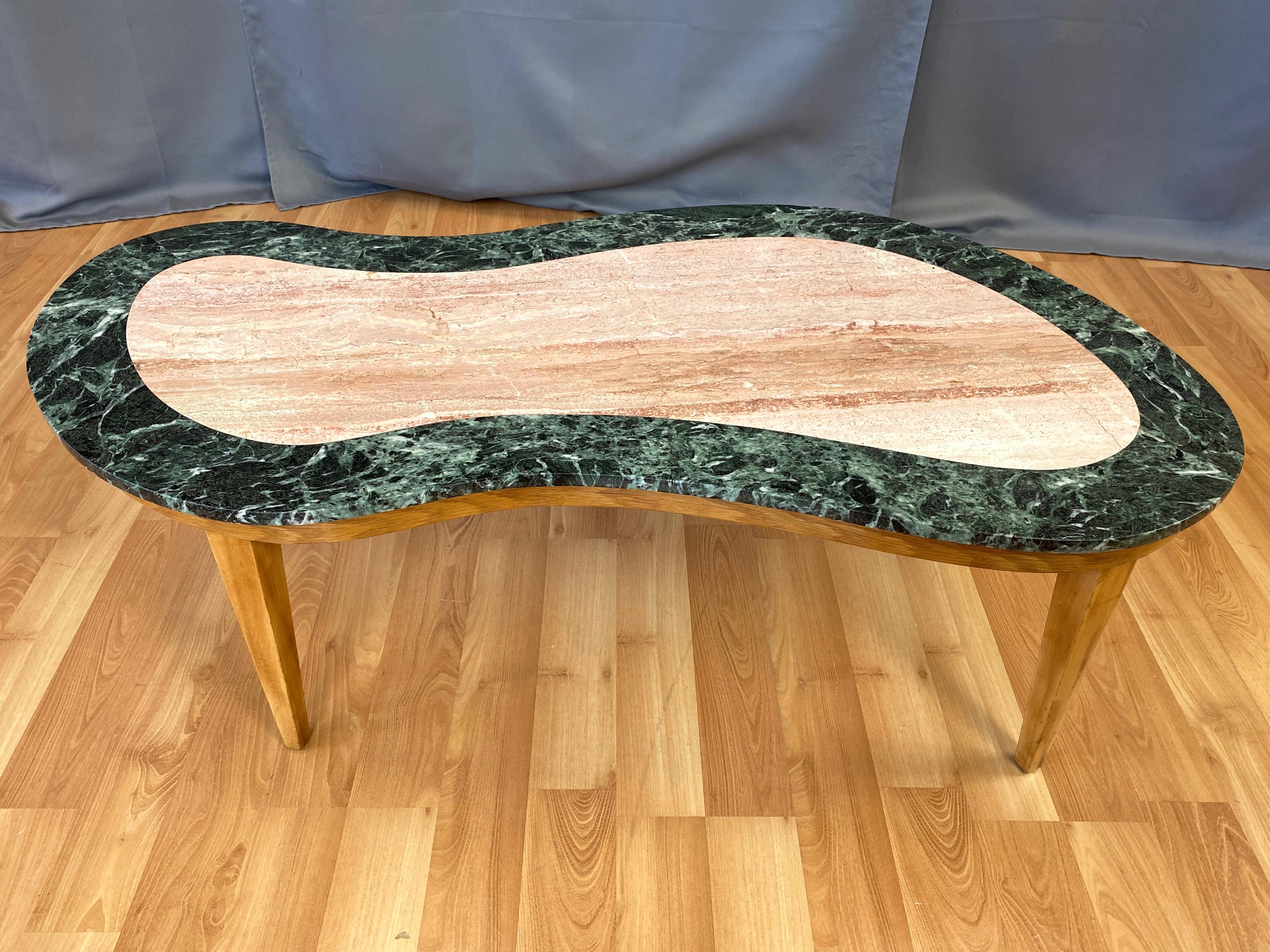A fabulous 1950s freeform marble and elm wood coffee table made in Italy by Continental.

Expansive top of beautifully striated muted pink marble with a broad and dynamically-patterned dark green marble border. Calls to mind a wind-swept desert