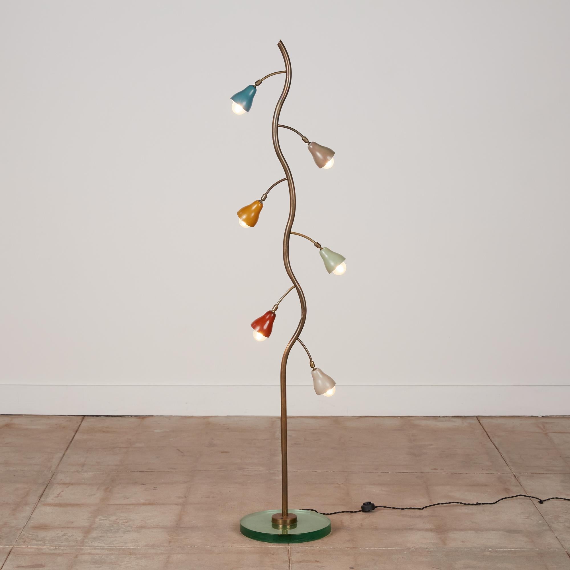 Tulip shade floor lamp, Italy, circa 1960s. The lamp features a freeform shaped brass stem with a circular green glass base. There are six multicolored enameled metal shades, in an organic tulip-like shape. Each of the small shades are adjustable.