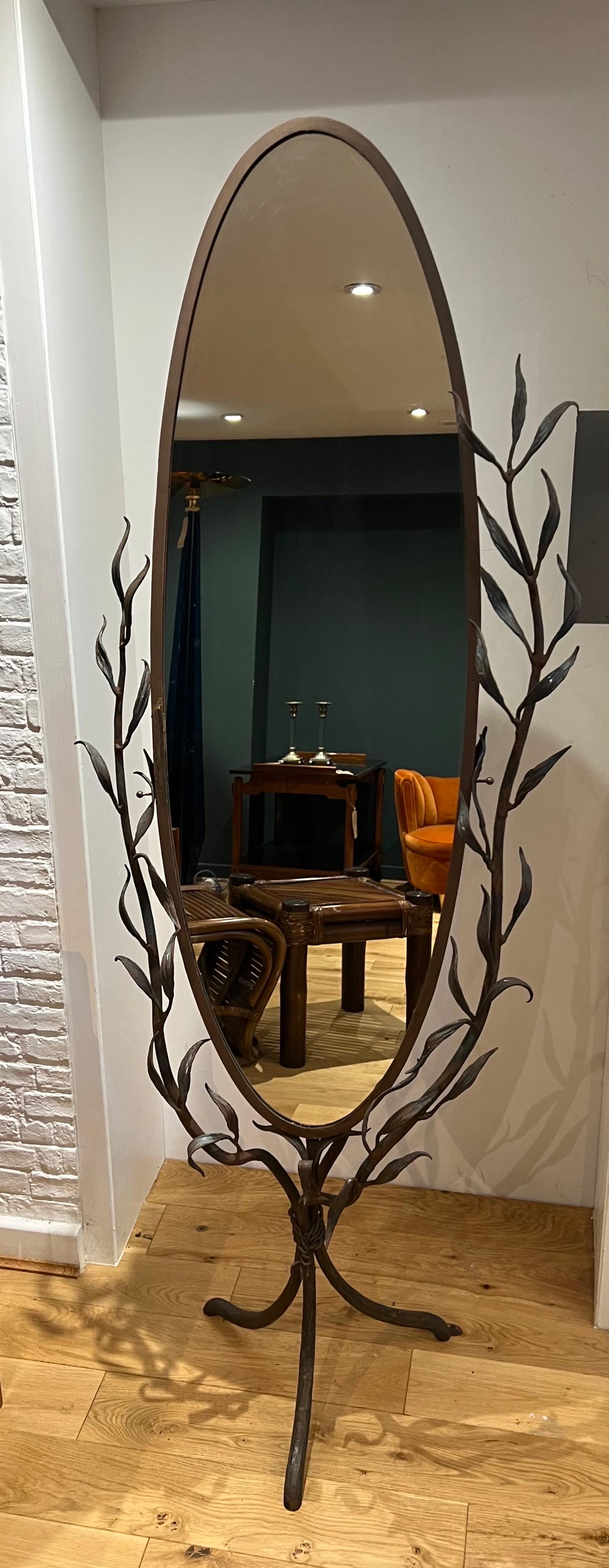 A hand built, unpolished, iron work, free standing vanity mirror with intricate leaf and branch detailing.