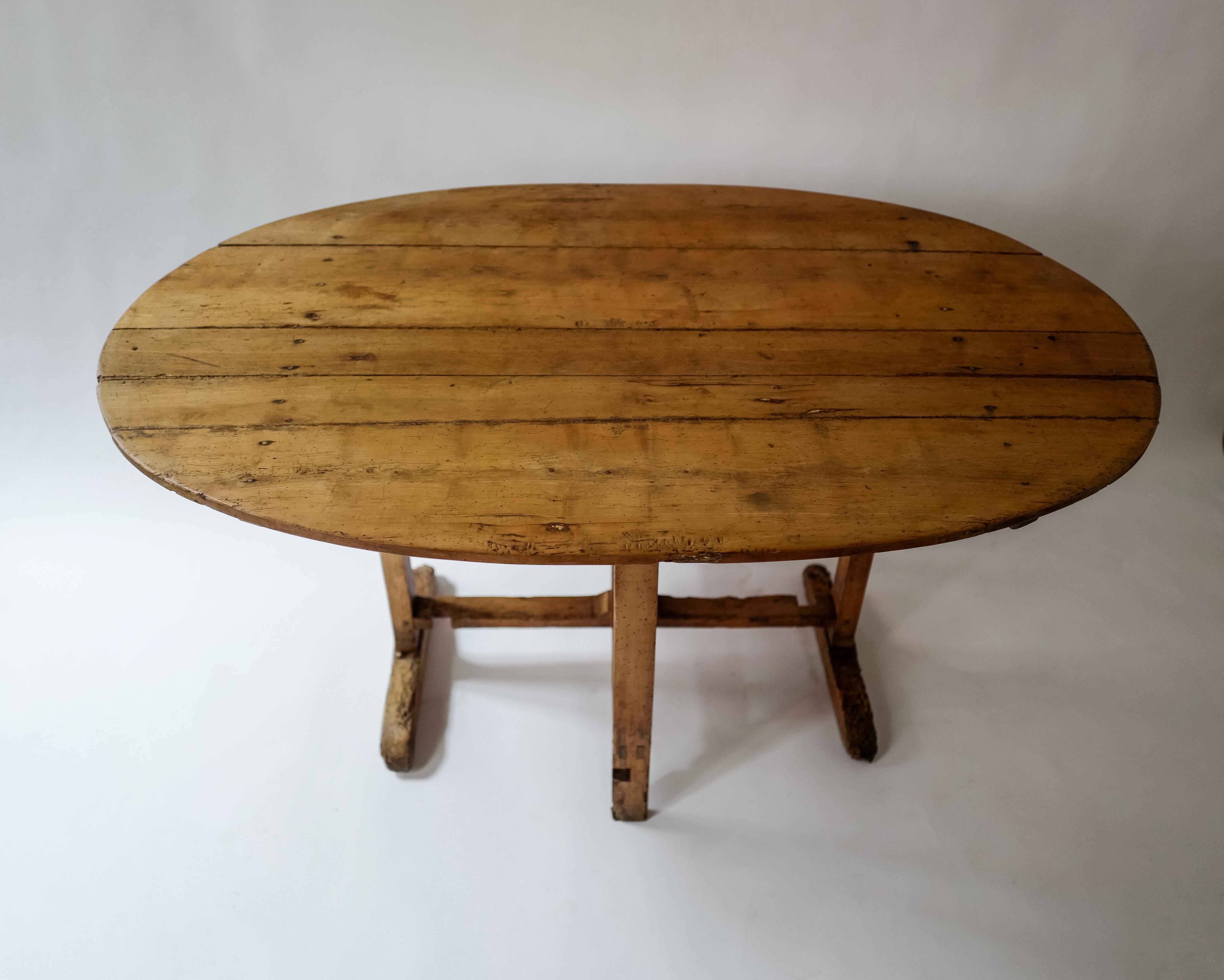 Cette superbe table ovale en pin des Alpes italiennes/françaises du XIXe siècle à plateau basculant présente une magnifique patine usée par le temps, reflet de sa riche histoire et de son savoir-faire artisanal. Son design élégant est doté d'un