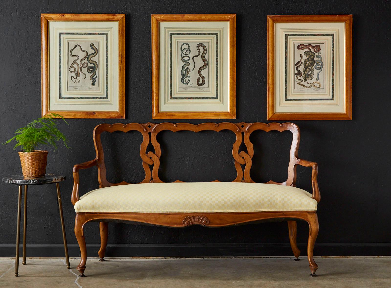 Gorgeous Italian fruitwood settee or canapé carved in the Venetian style. Features an interlocking design on the back decorated with small scrolls and quatrefoils. The arms measure 25.5 inches high and conjoin to a generous seat with curved ends and