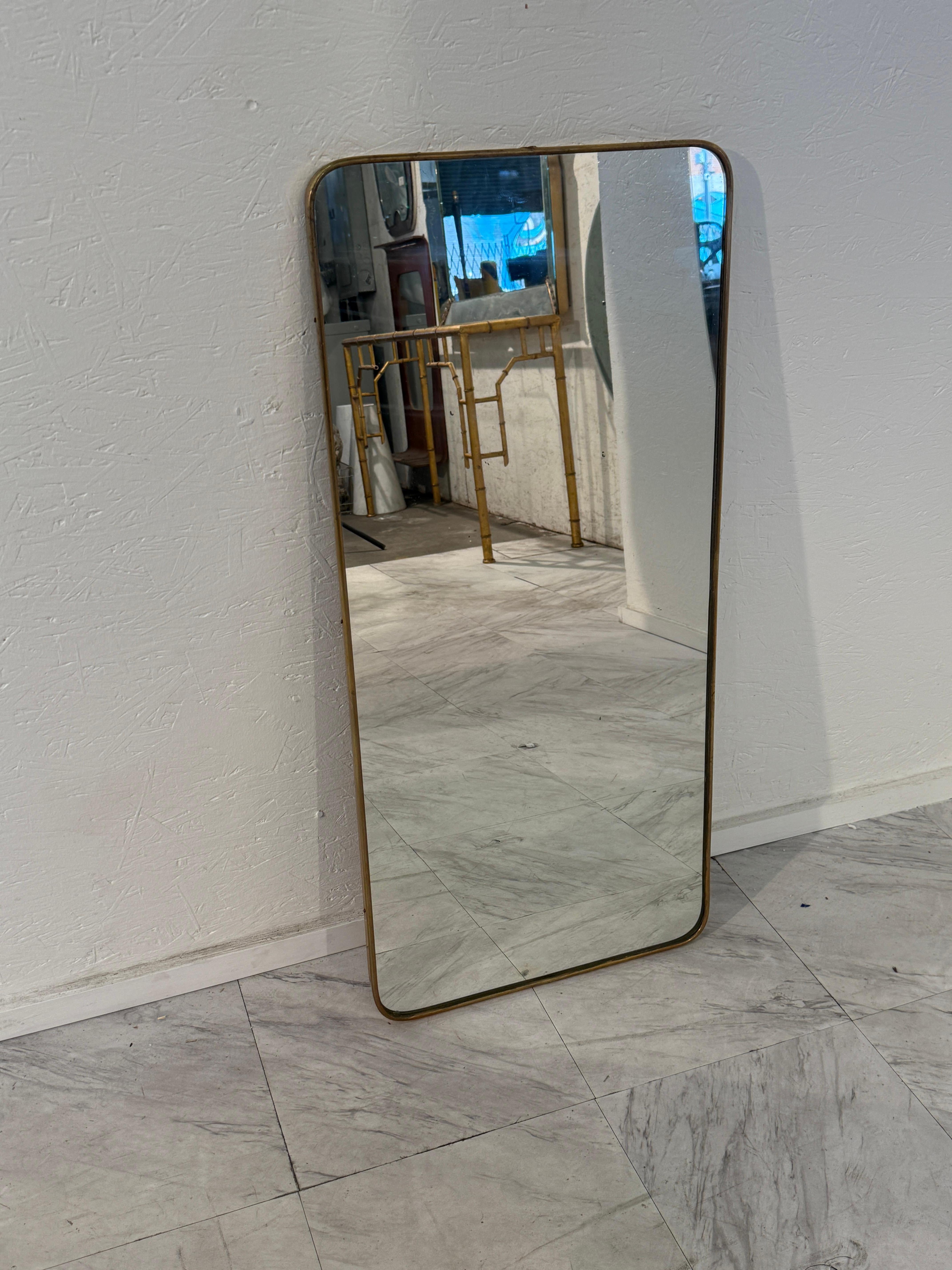 Un élégant miroir italien, mural ou de sol, encadré de laiton fin avec des coins doucement arrondis. Son design minimaliste et ses bordures métalliques chaudes incarnent l'élégance du milieu du siècle, offrant un accent intemporel qui complète à la
