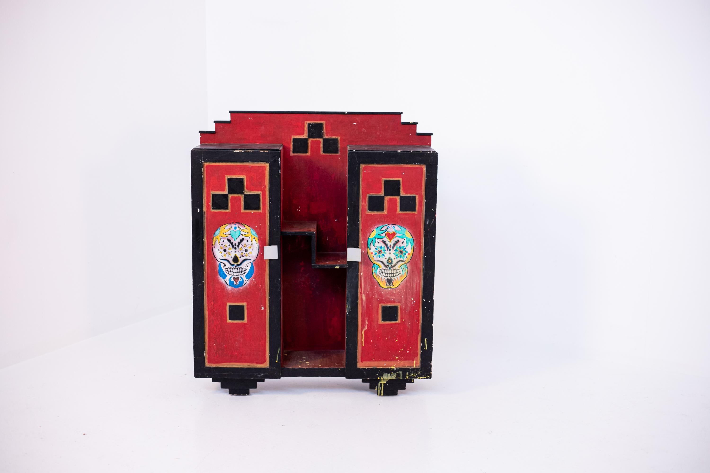 Eccentric Italian futurist showcase cabinet from the 20's. The cabinet has applications inserted later, such as skull-shaped designs and designs on the sides of the cabinet in the shape of a sword. The cabinet is made with well-defined and geometric