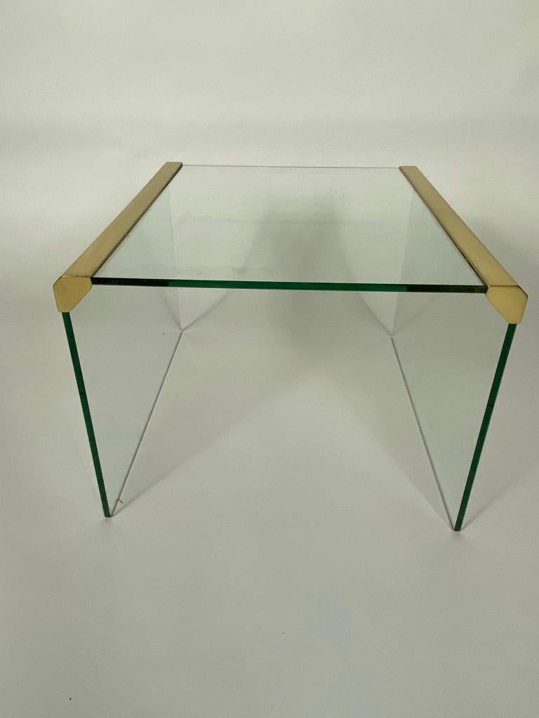 Unique Italian side table made of heavy 8mm transparent glass with brass accents. Designed by Pierangelo Gallotti and produced by Gallotti & Radice in the 80s. The simple shapes give the table a characteristic and luxurious appearance. In good