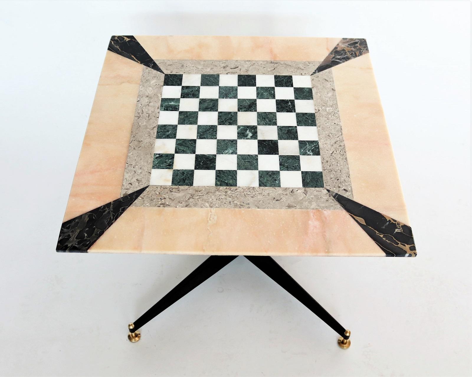 Stunning coffee table or gaming table made in Italy in the 1950s with original metal base with brass tips.
The marble mosaic have been fixed completely on Travertine marble base, the table top is made of different marble types: Portoro marble (one