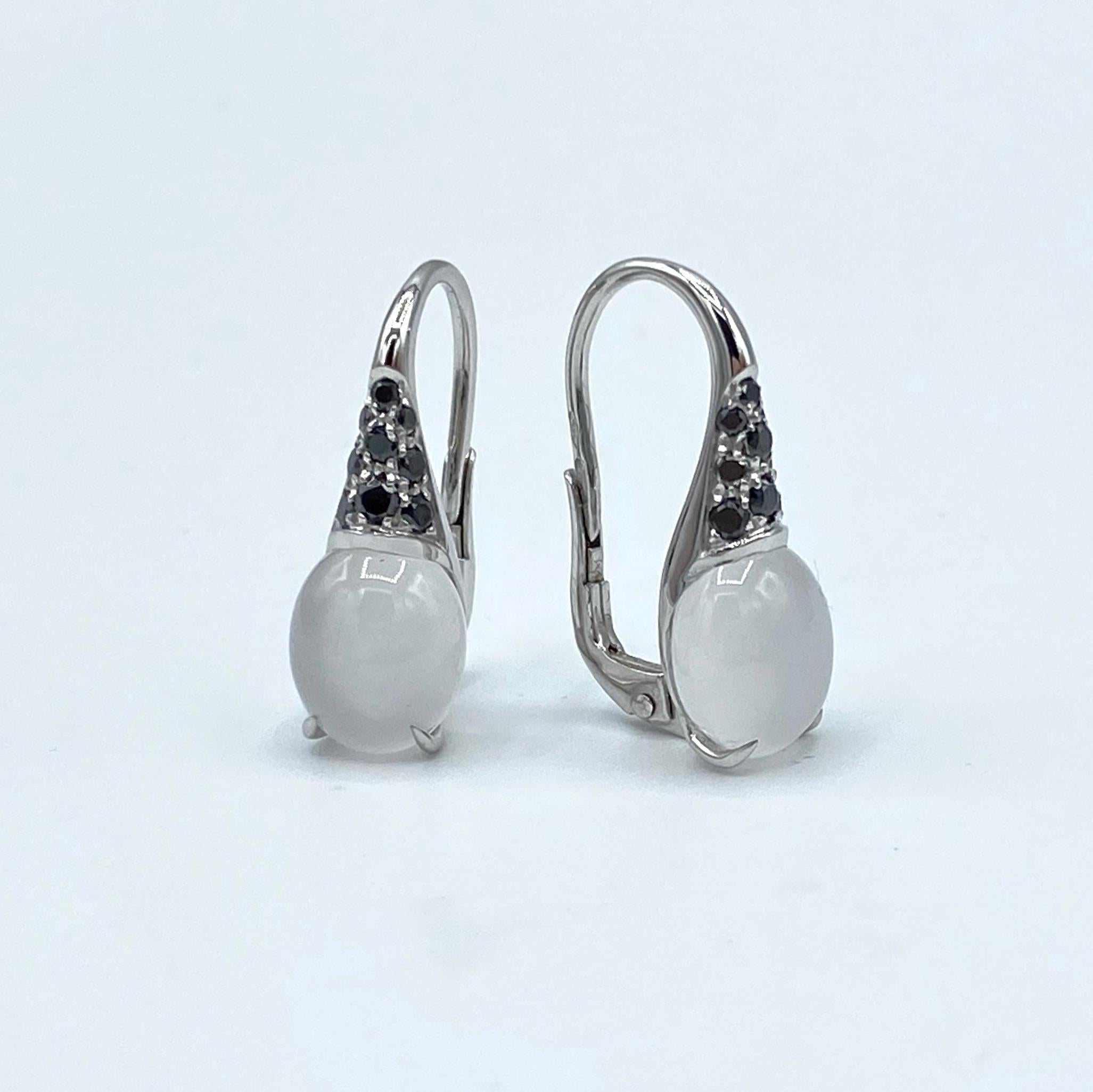 Boucles d'oreilles pendantes en or blanc 18 carats, diamant noir et quartz, pierres italiennes 

Ces boucles d'oreilles sont composées de deux quartz laiteux taillés en cabochon de 8x10 mm et de diamants noirs ct 0,33 avec des clips à levier en or