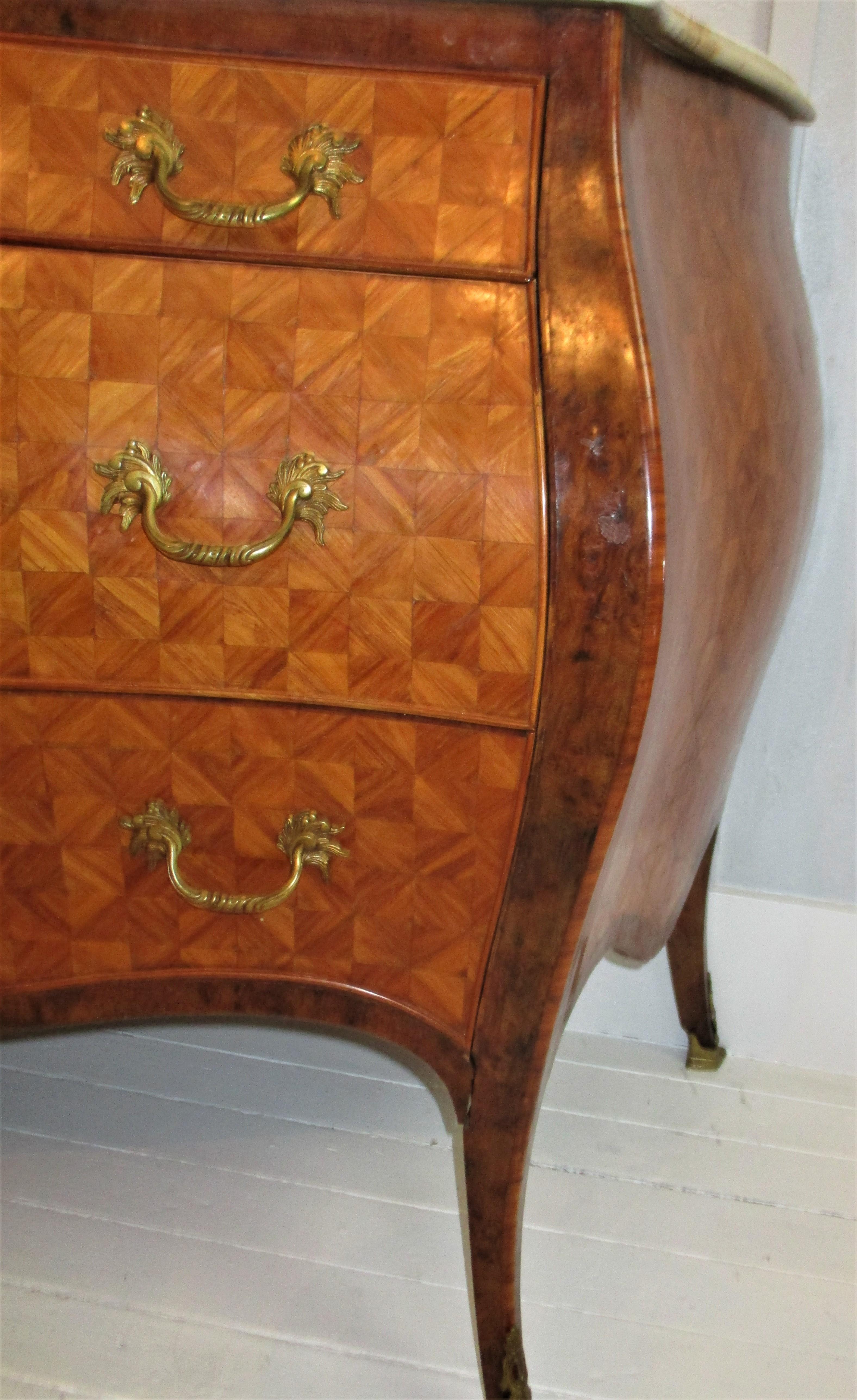 Italian 1960s marquetry inlay bombe commode with Italian Calacatta gold marble top. The marquetry design on this fine piece projects a three dimensional pattern that is quite lovely. Marquetry is a process of creating patterns and designs on objects