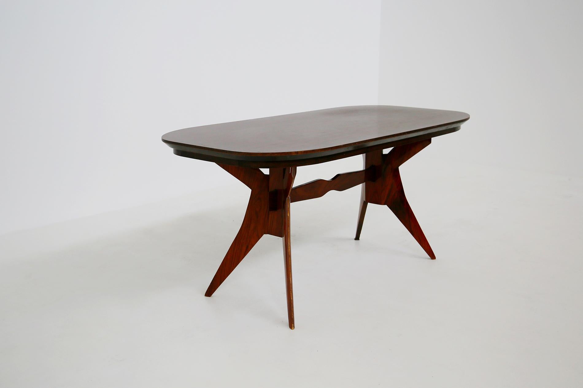 Geometric Italian table of the Turin school of 1950.The table is made of an elegant and well defined wood. Its top is elliptical in good condition. The peculiarity of the table lies in its sculptural legs with geometric shapes, an elegant game of
