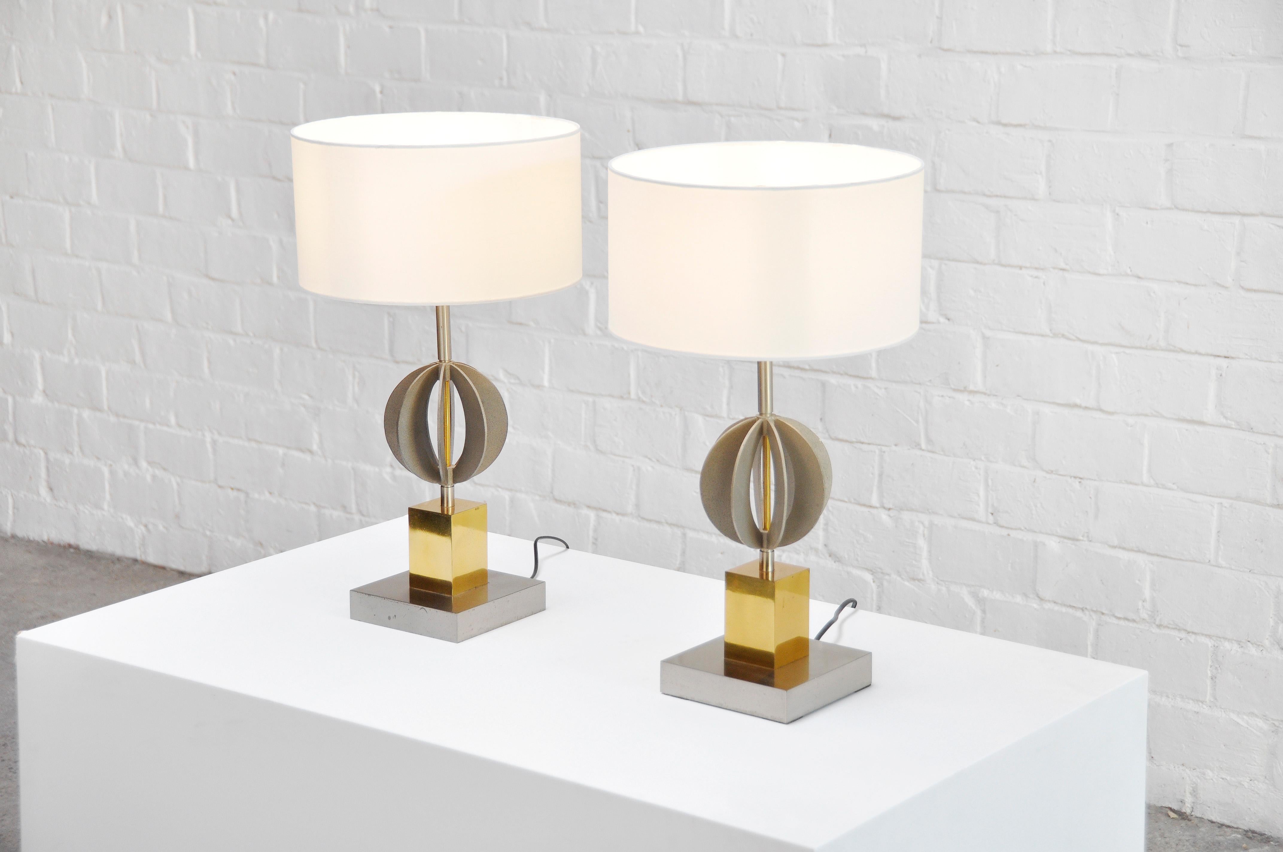 A pair of sculptural/geometrical table lamps made in Italy around 1970. Composed of a chrome and brass structure, the lamps feature a ball shaped geometrical body. Topped with round white cotton fabric lampshades.


In great original condition,