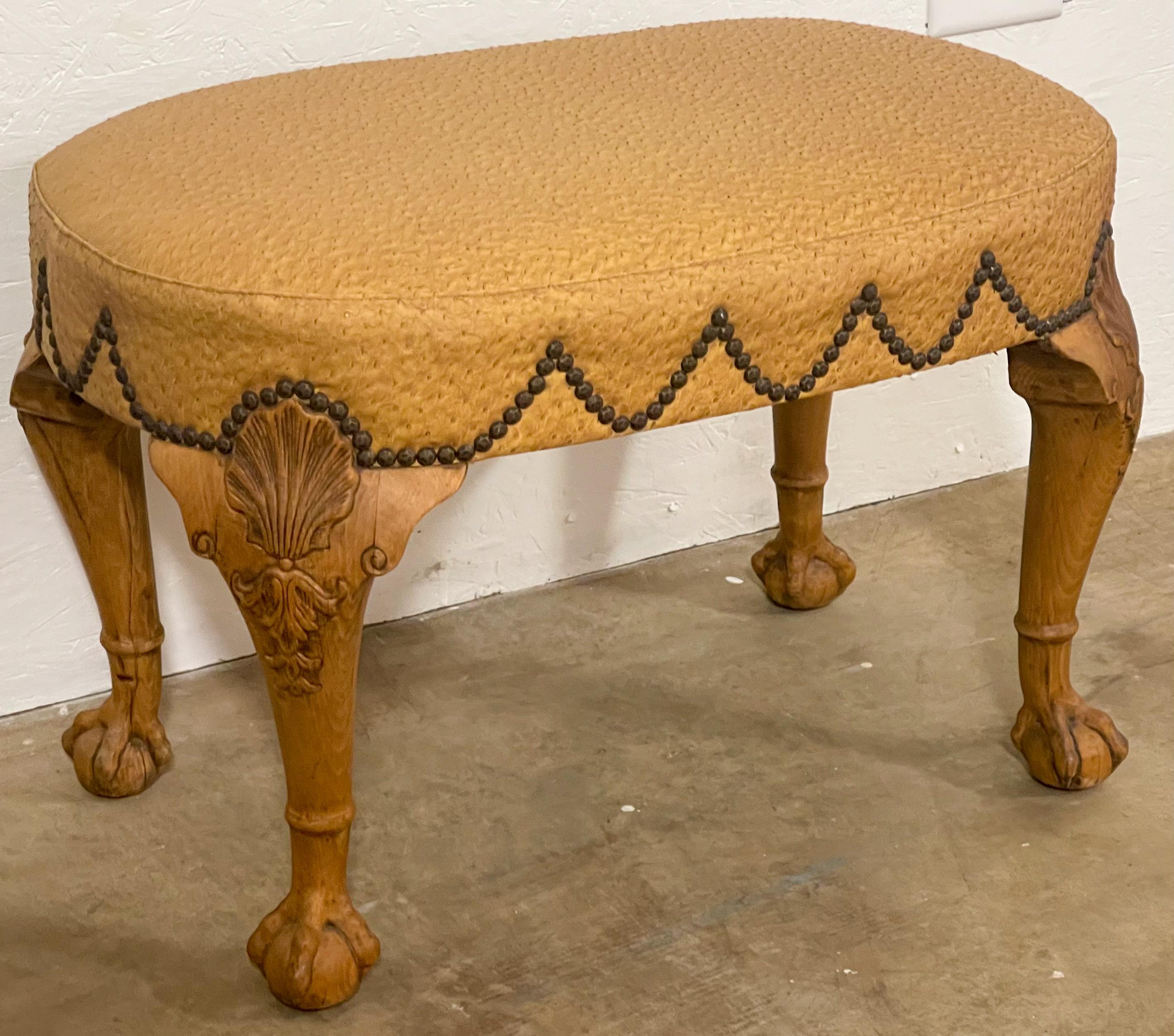 This handsome bench is upholstered in ostrich leather. It is English with Georgian styling. Note the detailed carved with the ball and claw feet! The draping nailheads add a nice touch. It is unmarked.