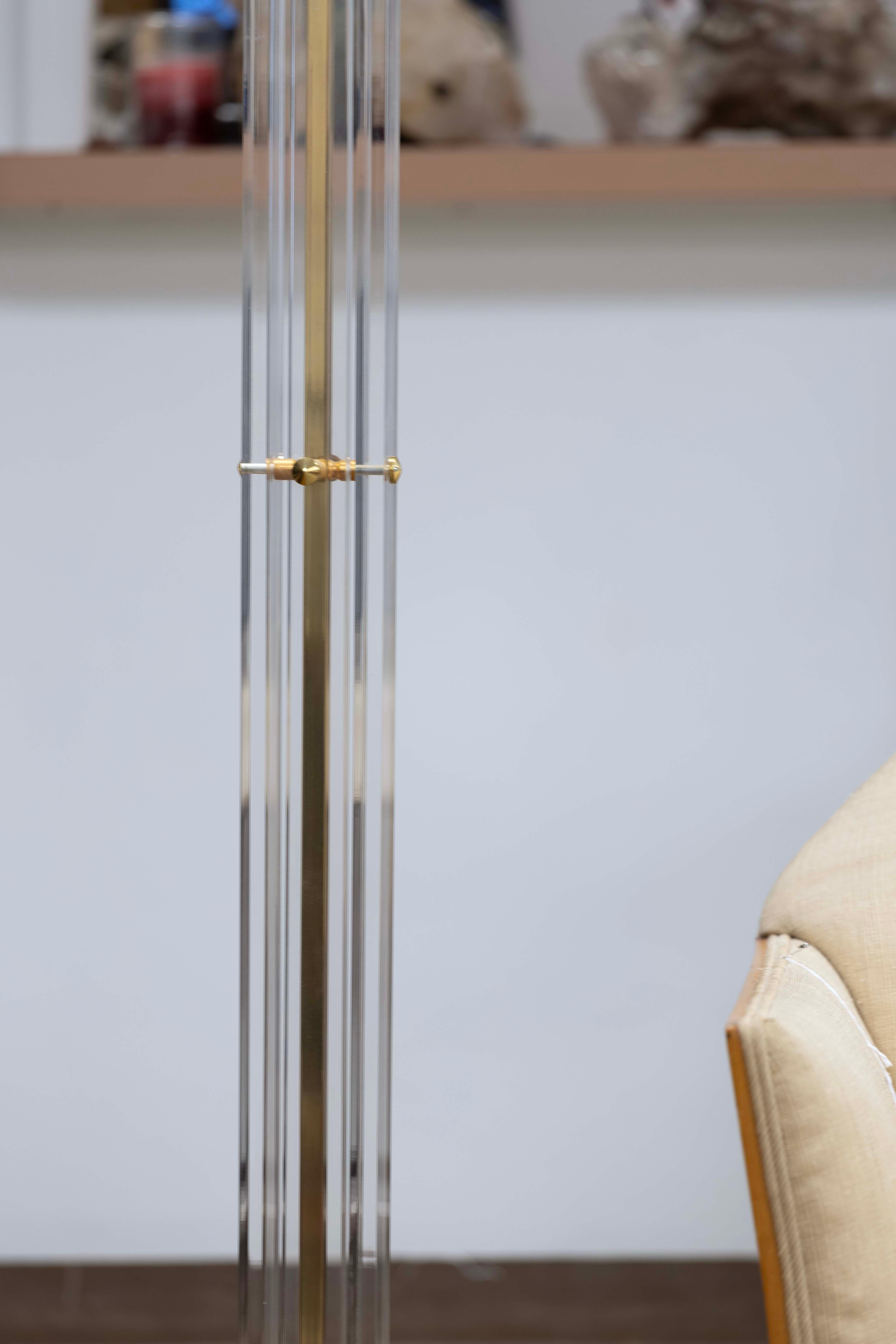 Lampada da terra Torchiere in ottone dorato e lucite, circa anni '70. Questa splendida lampada da terra incarna l'essenza del design italiano. La curva elegante della lucite e gli accenti in ottone permettono a questa lampada torchiere di essere un