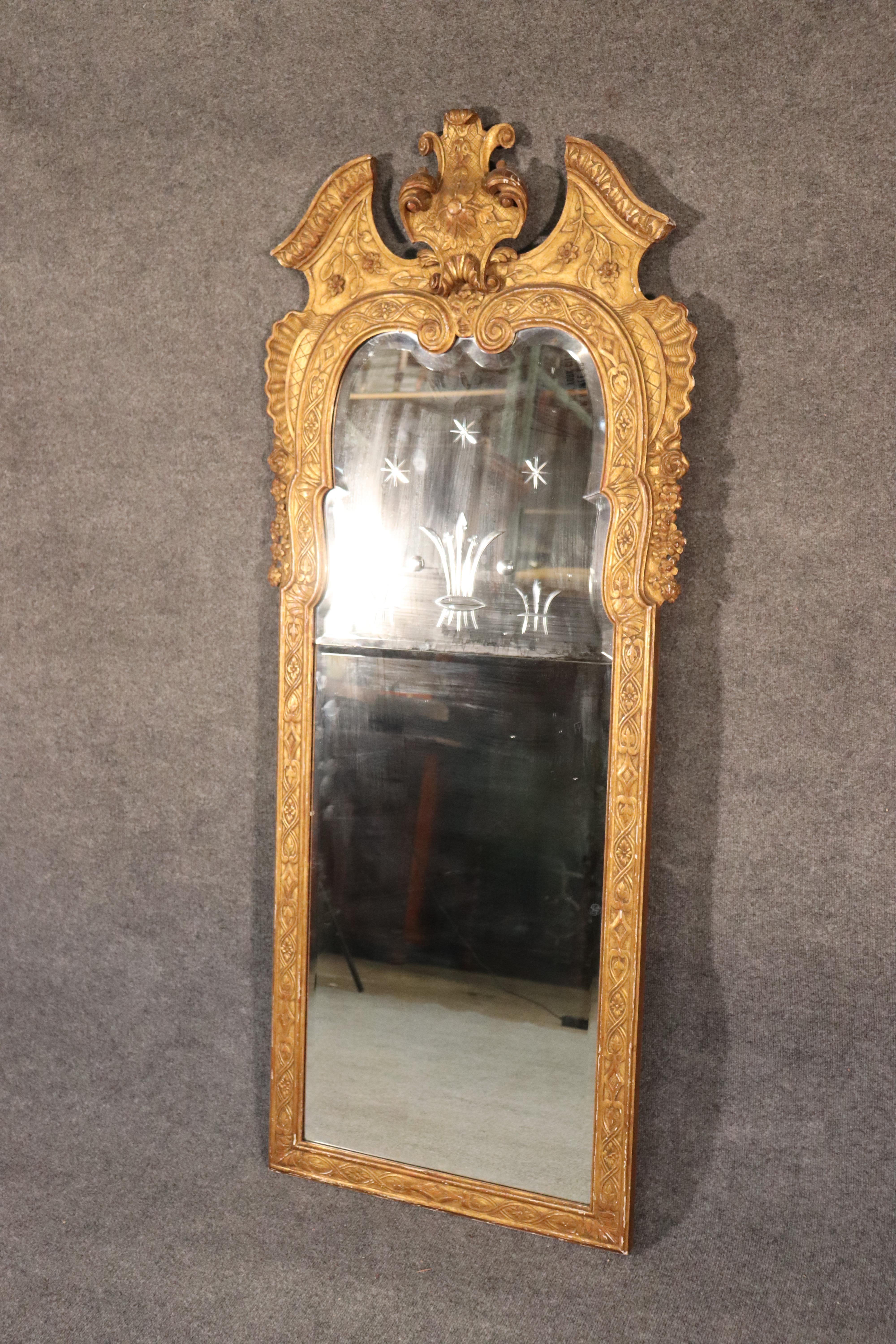 This is a beautiful antique etched and gilded Venetian mirror. The mirror is in good condition with minor signs of age and wear from time. The frame is carved wood with a gorgeous gold leaf finish. The etched glass is simple and sophisticated. The