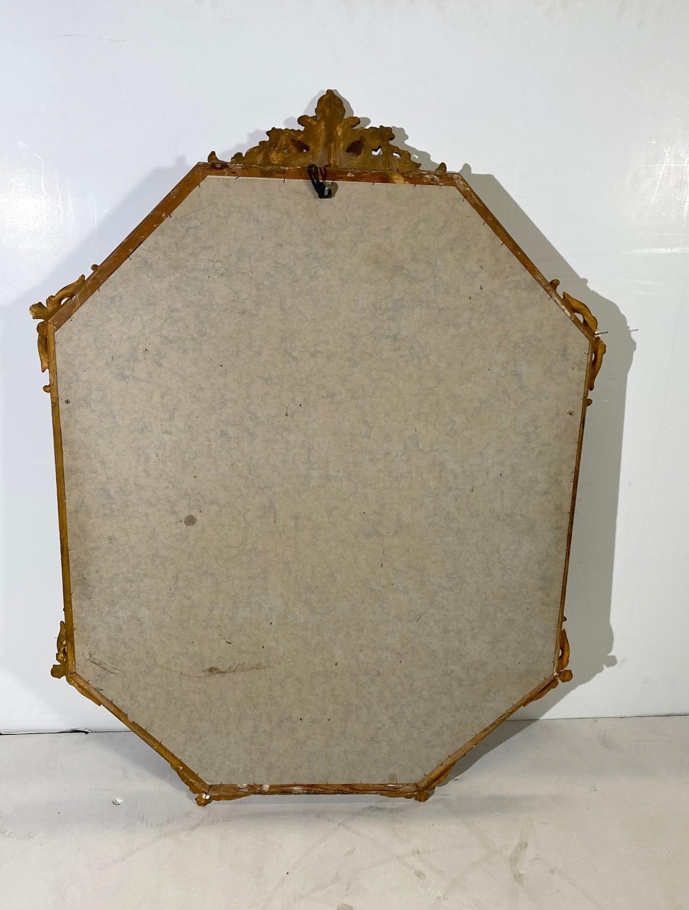 Italian wall mirror. The frame is wood. The carving is made in gesso with gold gilding. 