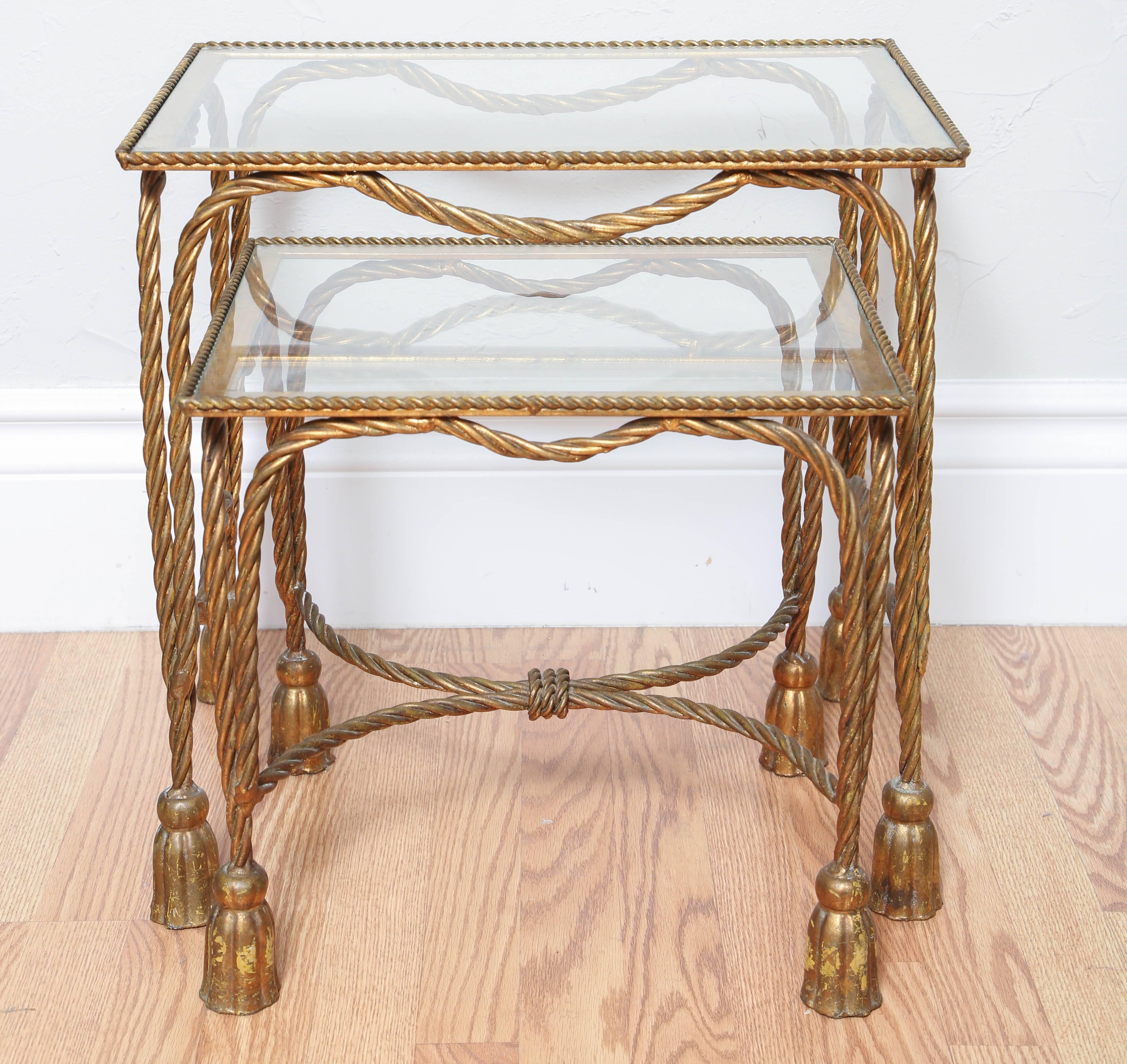 Italian gilt metal stacking tables in the twisted rope and tassel motif.