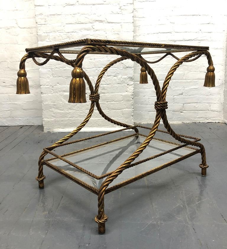Italian gilded rope and tassel two-tier side table. The table is metal with a glass top and bottom. Glass is removable.   Can also be used as a bar cart.