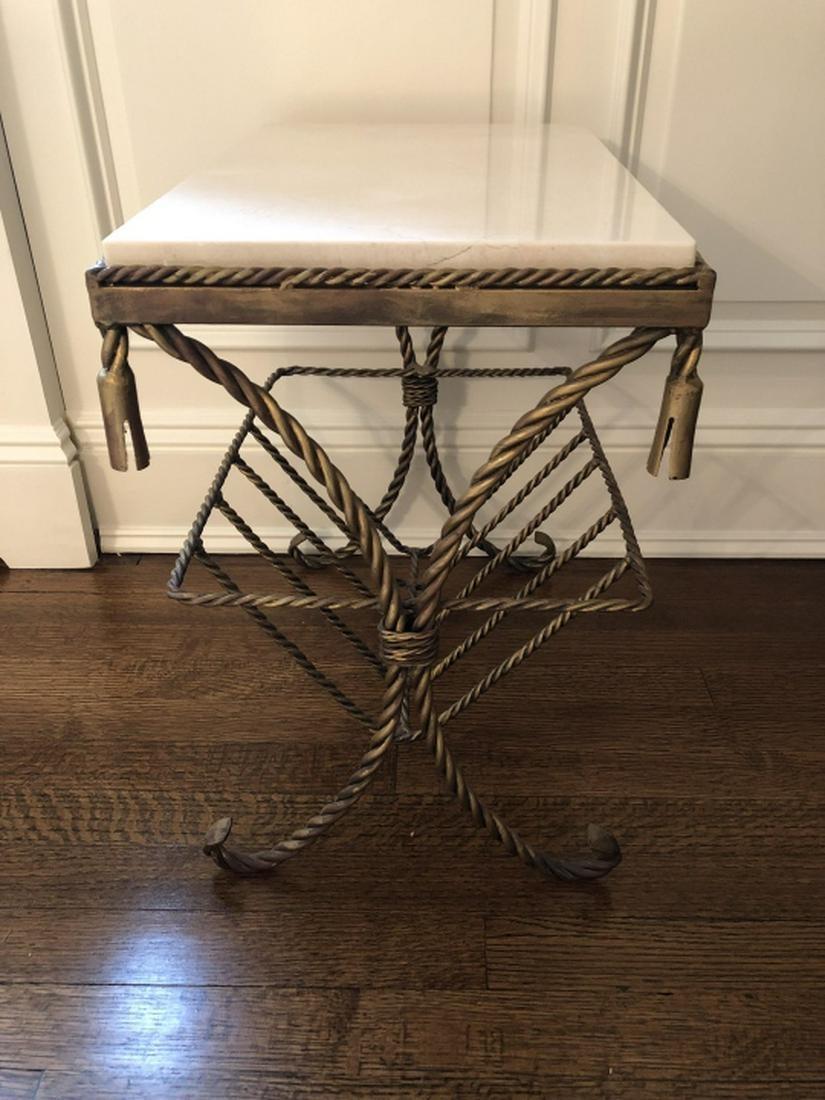 Hollywood Regency gilt marble-top table with magazine rack. Gilt metal in a twisted silk cord and tassel motif forms the base of the table with the added feature of a basket underneath serving as a magazine rack or a catch all. Great as side table