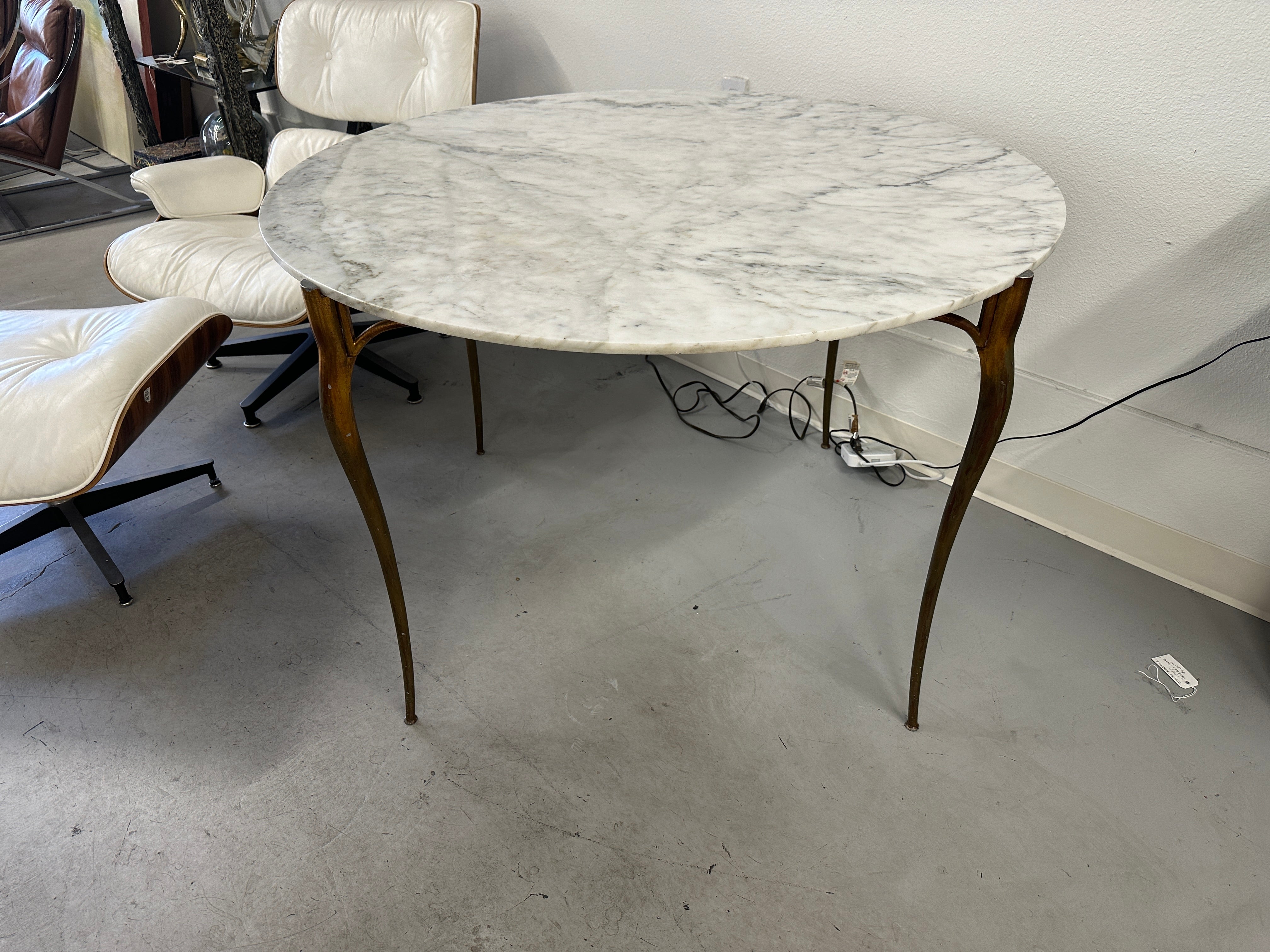 A wonderful Italian Gilt Aluminum and Marble dining table suitable in a Kitchen or small dining room. Very much reminiscent of the Italian masters like Gio Ponti or Ico Parisi. Flowing delicate legs and a simple but elegant apron. The round marble