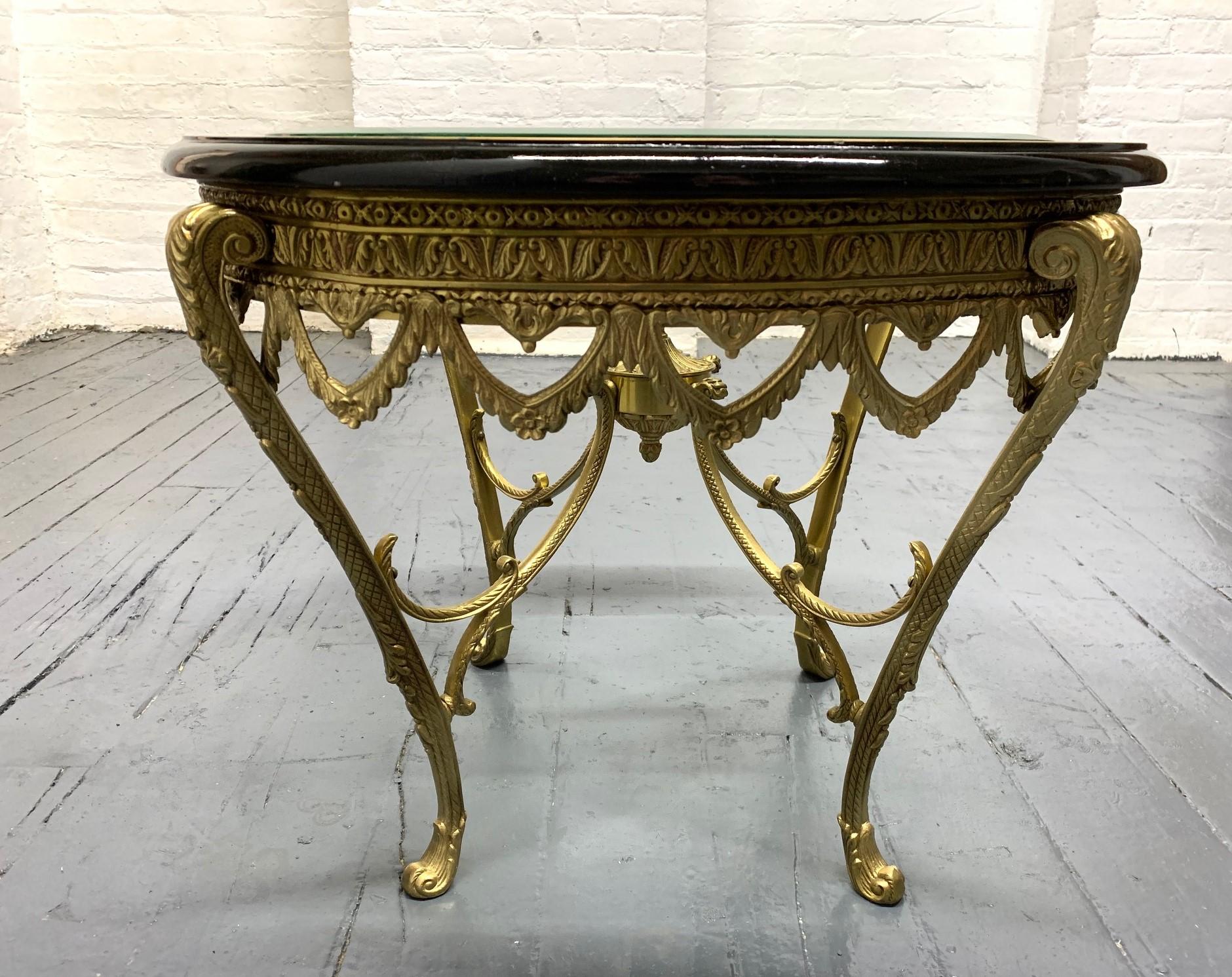 Italian gilt bronze table with an ebonized top and mother of pearl inlay. Beveled glass.