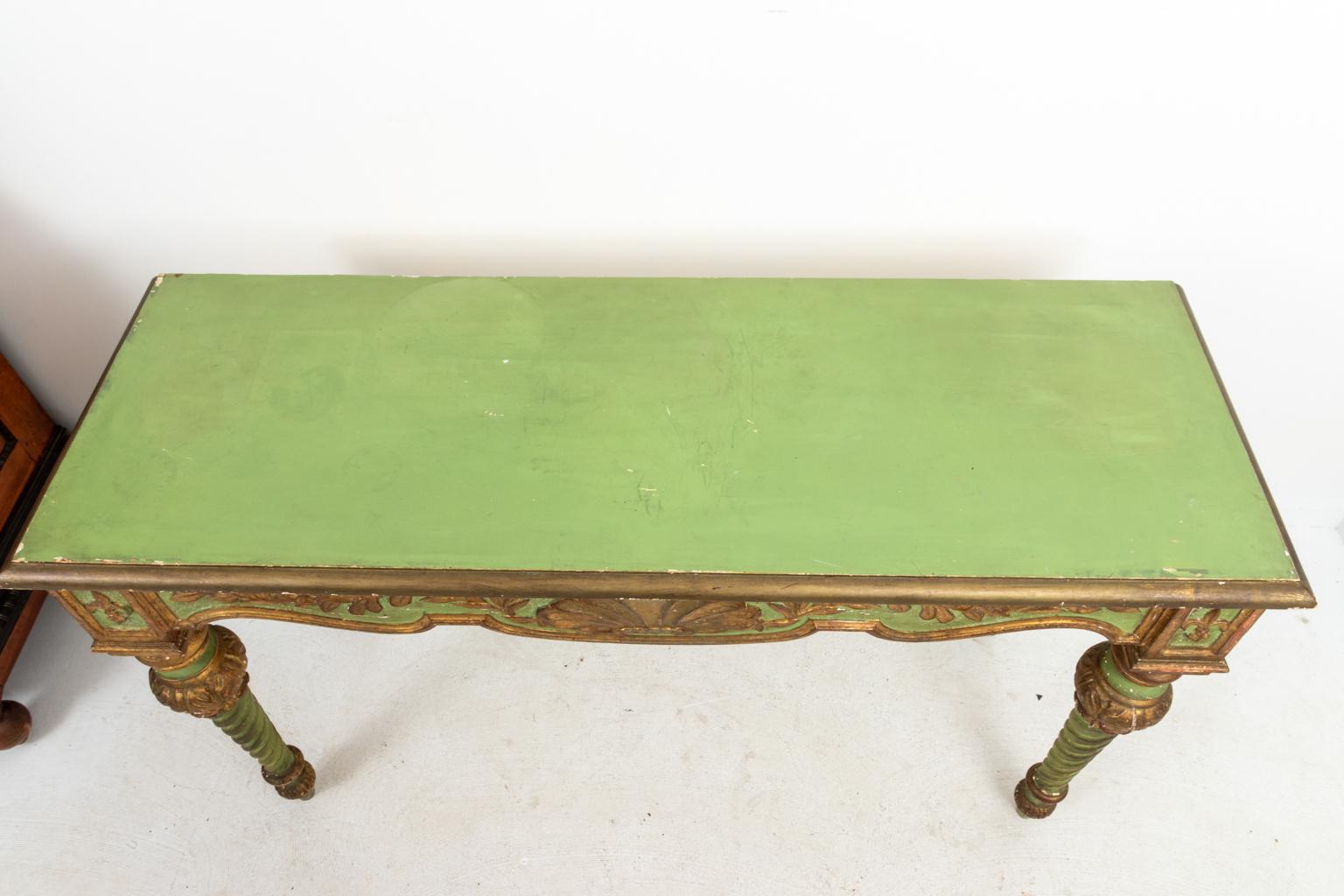 Green painted Italian console with gold gilt trim, circa 1940s. The piece also features a carved and gilded apron with scallop shellwork supported by carved and turned barley twist legs, made in Italy. Please note of wear consistent with age