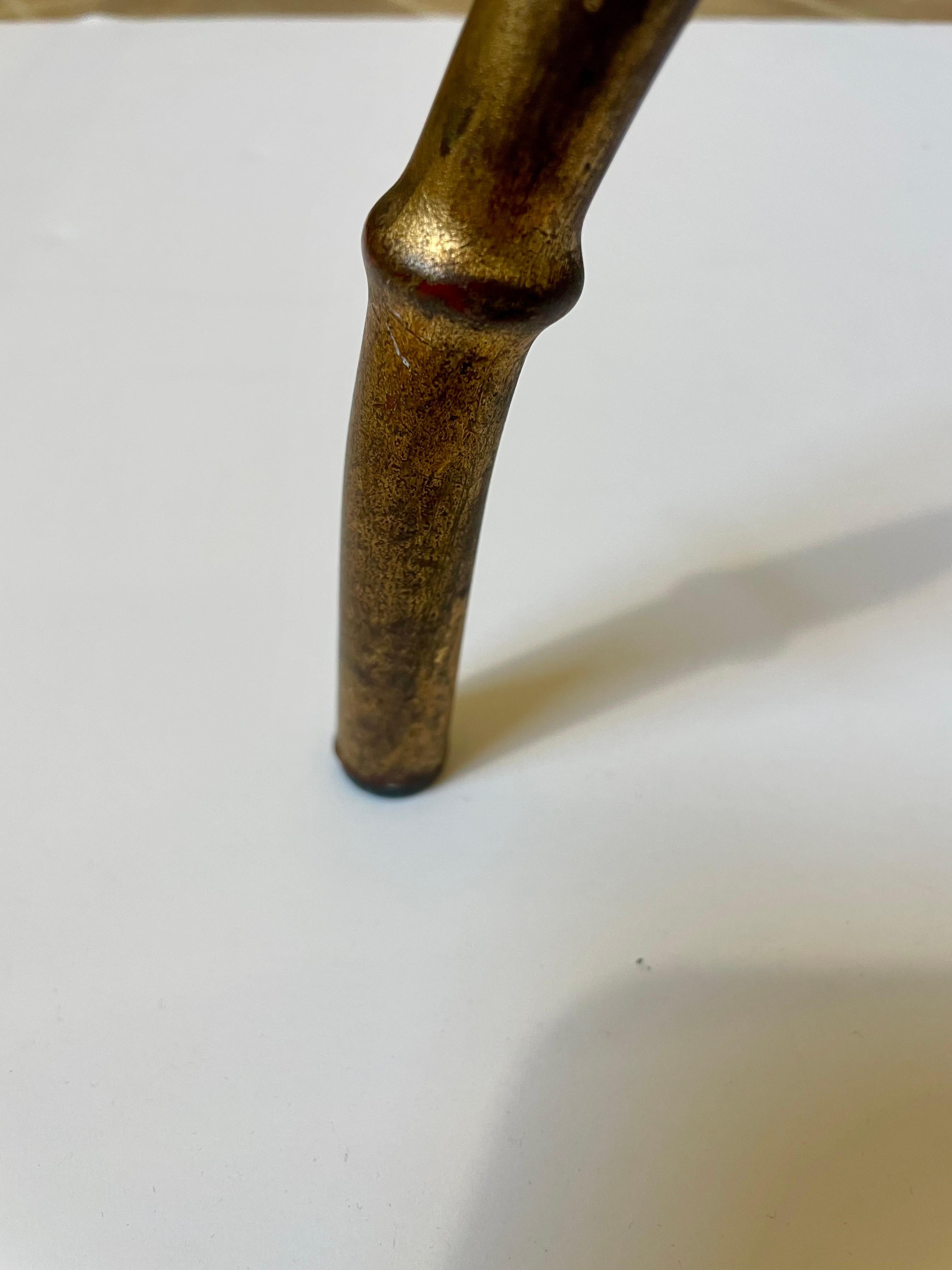 Table basse italienne en métal doré et faux bambou avec plateau en verre. Finition dorée naturellement vieillie par l'âge et l'usage pour une sensation de chaleur agréable.  Quelques rayures sur le verre. Robuste et prêt à l'emploi.