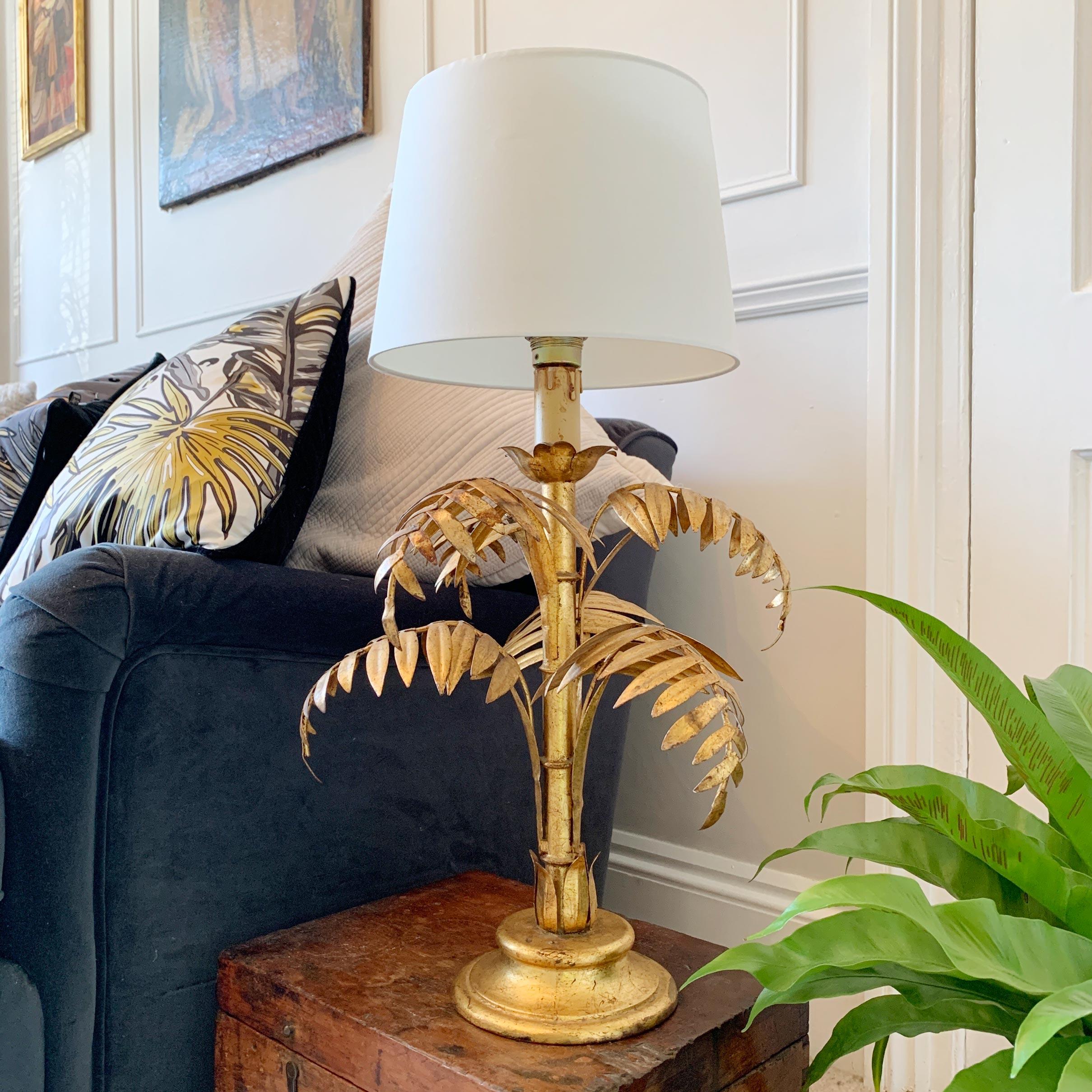 1950s Italian gilt metal table lamp, detailing a central faux bamboo stem with palm leaves. 
The lamp has been fitted with a modern replacement shade.

Including shade 64cm height , width 46cm
Excluding Shade 50cm height , width 46cm
Base width