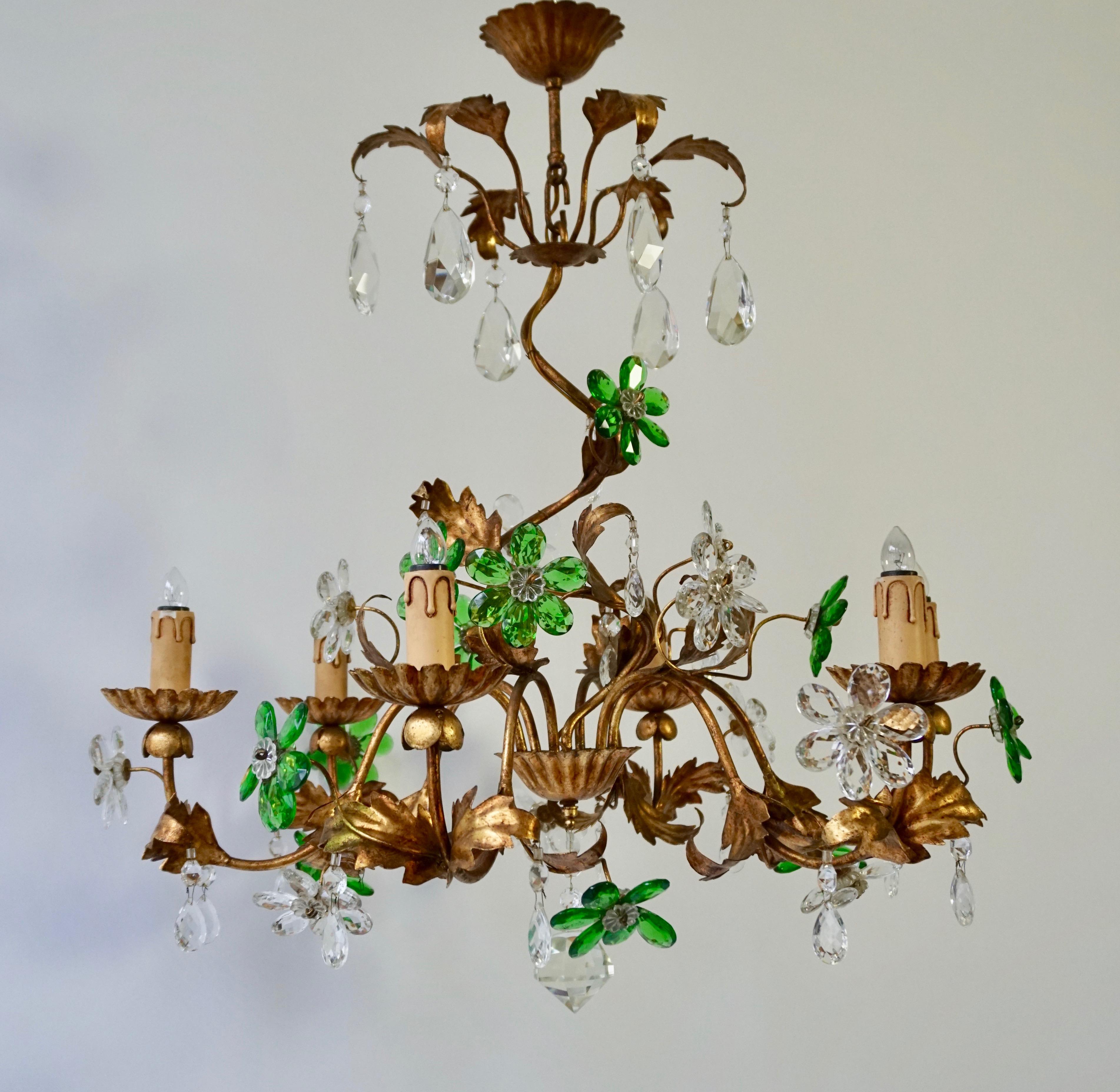 Floral Italian gilt iron chandelier, with glass flowers. The central stem, supports six E14 bulbs.
The arms, fluidly interweave, with gilt leaves decorating throughout as well as green and transparent flowers.
Measures: Diameter 75 cm.
Height 80