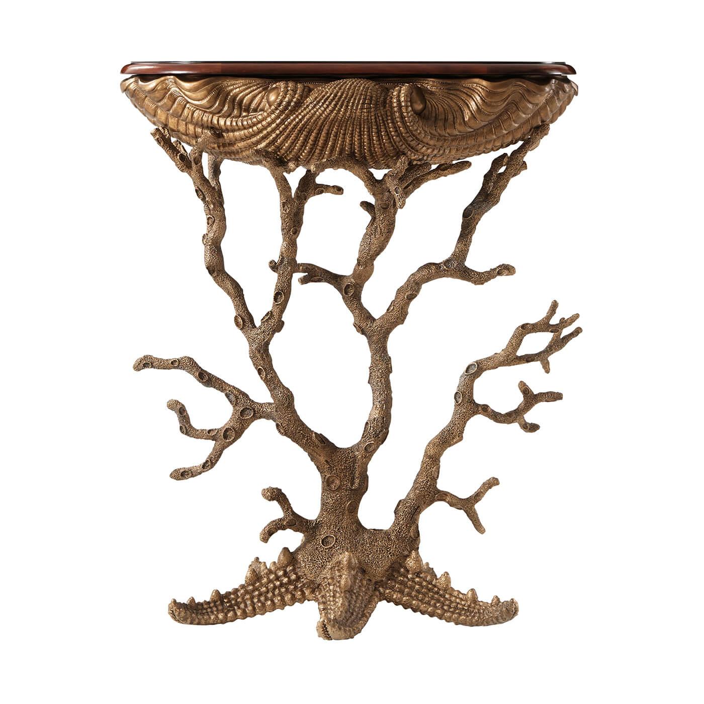 An unusual Grotto table, the rounded 'D' shaped flame mahogany and rosewood crossbanded top above a gilt metal cast base of a giant clamshell supported by coral legs issuing from a starfish. Inspired by Renaissance shell-decorated