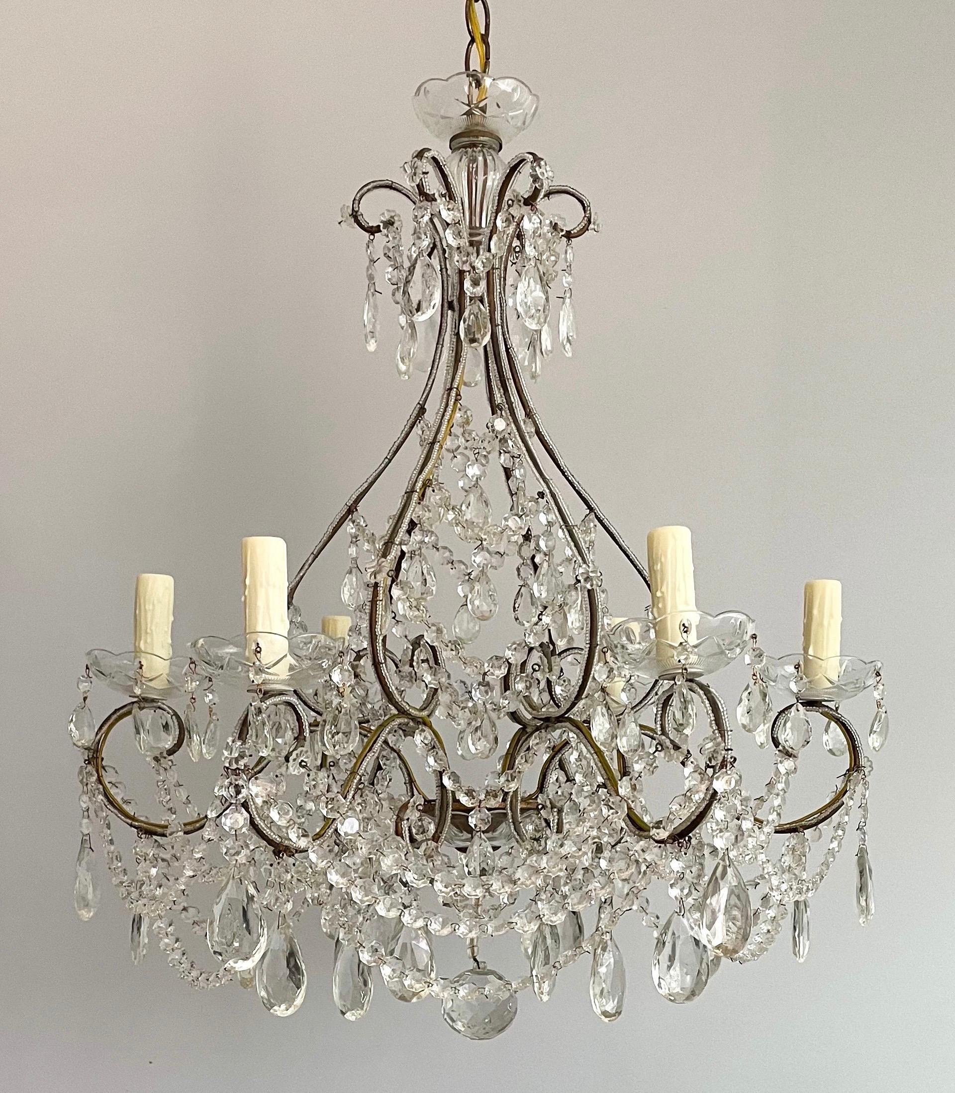 Beautiful, Italian 1940s gilt-iron and crystal beaded chandelier. 

 The chandelier consists of a scrolled iron frame with a gilt finish that has acquired a very pleasing, dark patina. A bounty of crystal prisms and bead garlands complete the