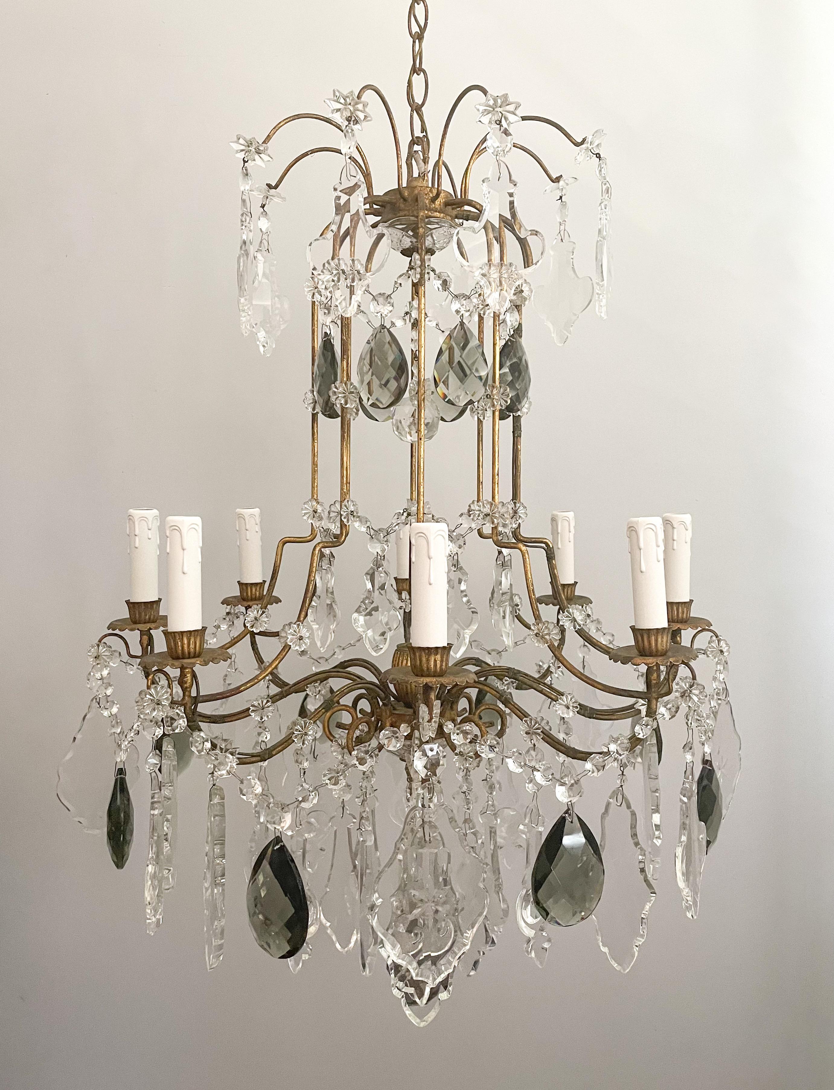 Beautiful, 1950s Italian gilt-iron and crystal chandelier in the neoclassical style.

The chandelier features a scrolled iron frame with a gilded finish and is decorated with an assortment of impressive crystal prisms including some very nice