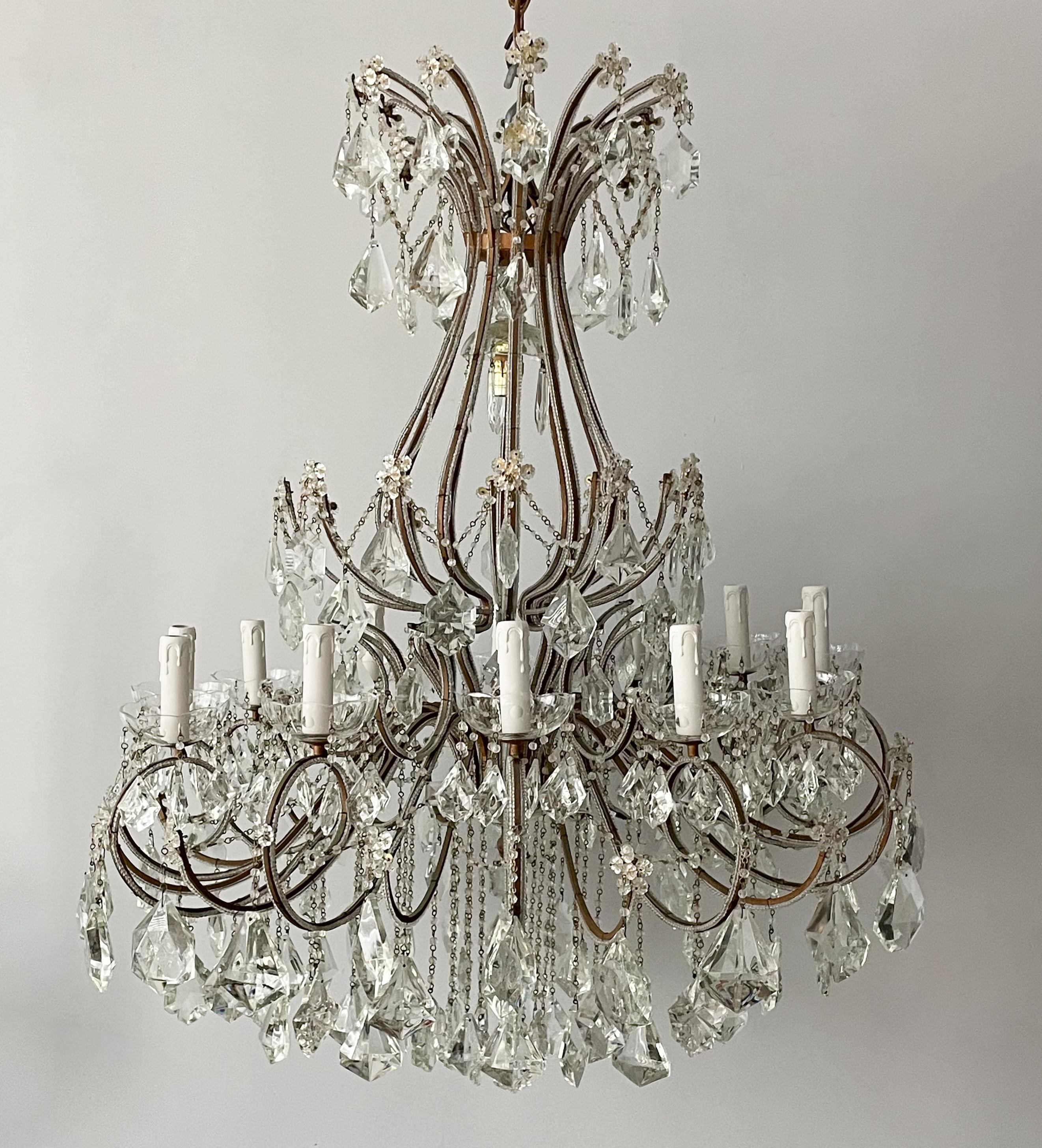 Gorgeous, vintage Italian large-scale gilt-iron and crystal beaded chandelier.

The chandelier features a graceful, scrolled iron frame in a gilt finish and an abundance of faceted prisms in a variety of shapes. 

The chandelier is wired and in