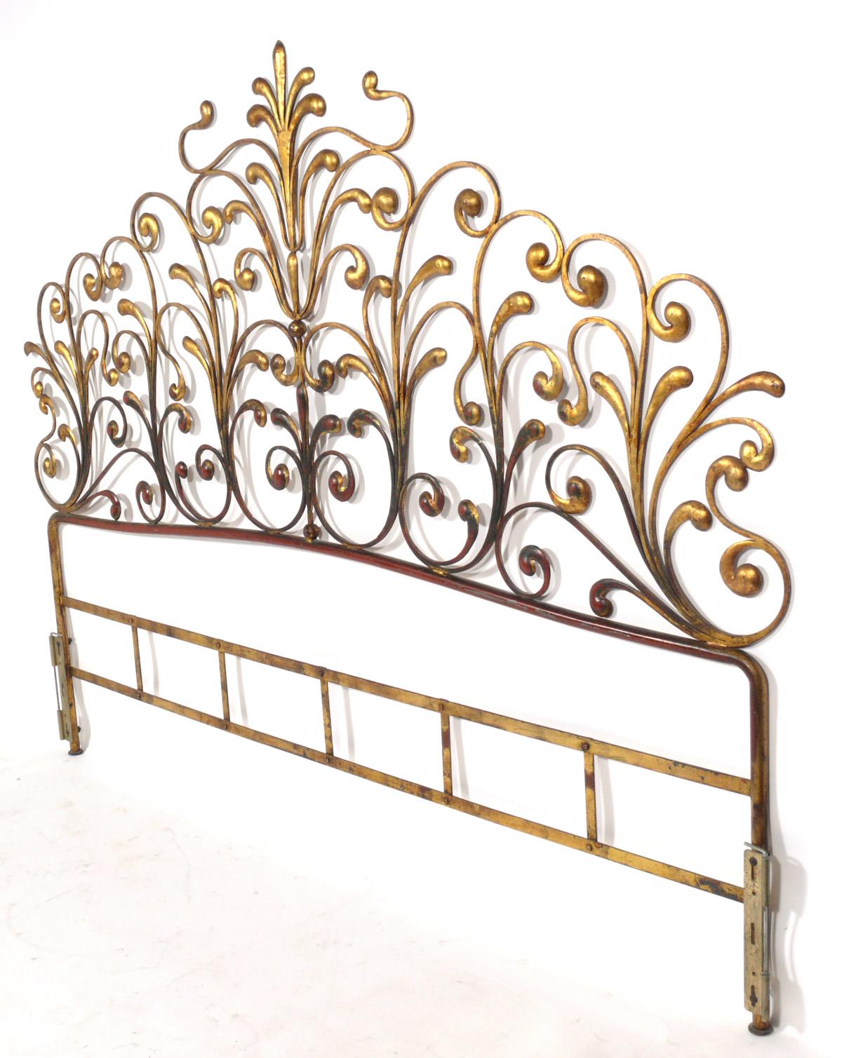 Glamorous gilt metal headboard, Italian, circa 1950s. It retains its original gilt finish with a wonderful patina with some overall wear to the gold leafed metal frame, exposing the Chinese red color underlayer or bole.