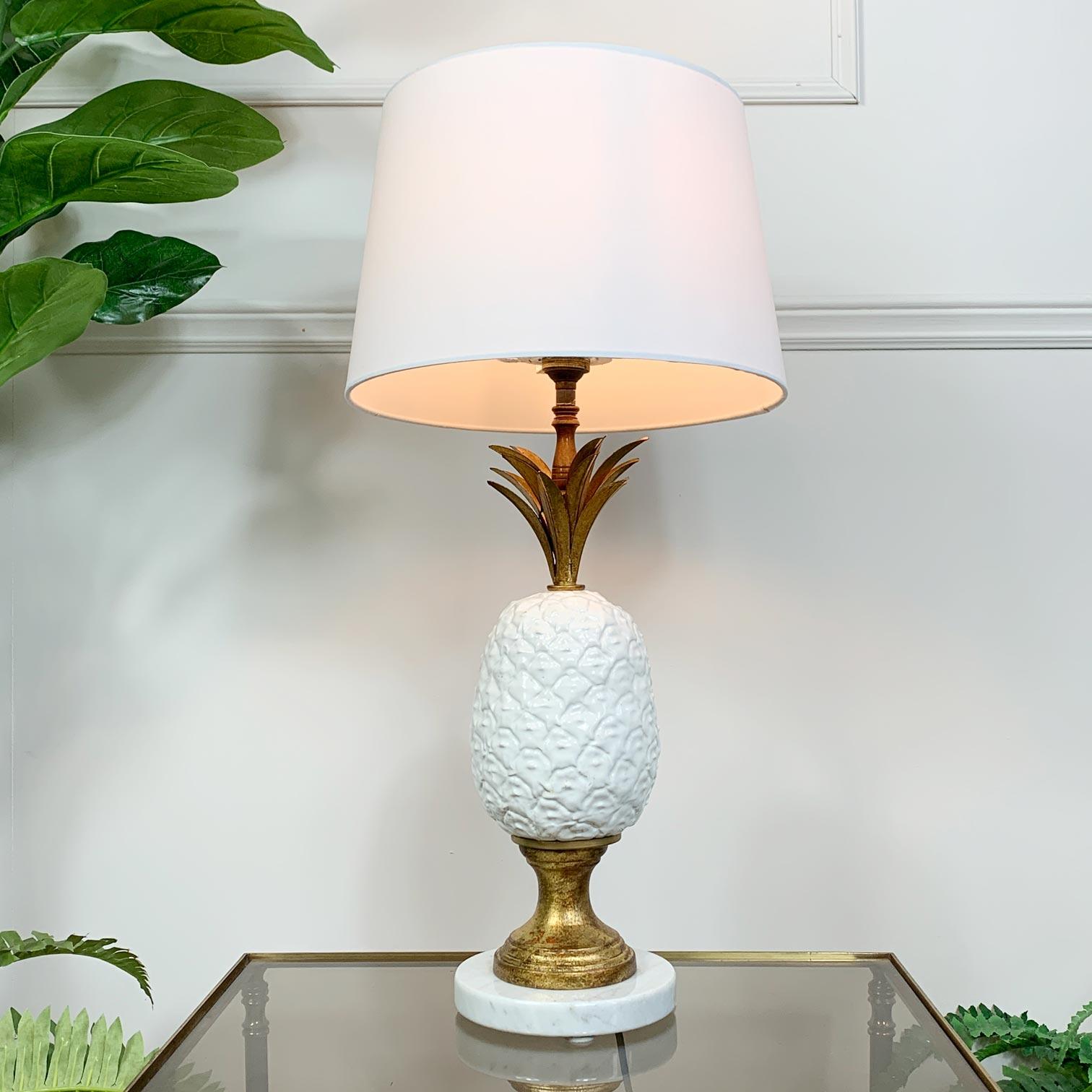 Magnifique lampe de table ananas des années 1950 en céramique blanche avec des frondes en métal doré et une base en marbre de carrare. Superbe pièce d'éclairage italienne du milieu du siècle fabriquée à la main, entièrement recâblée et testée.

La