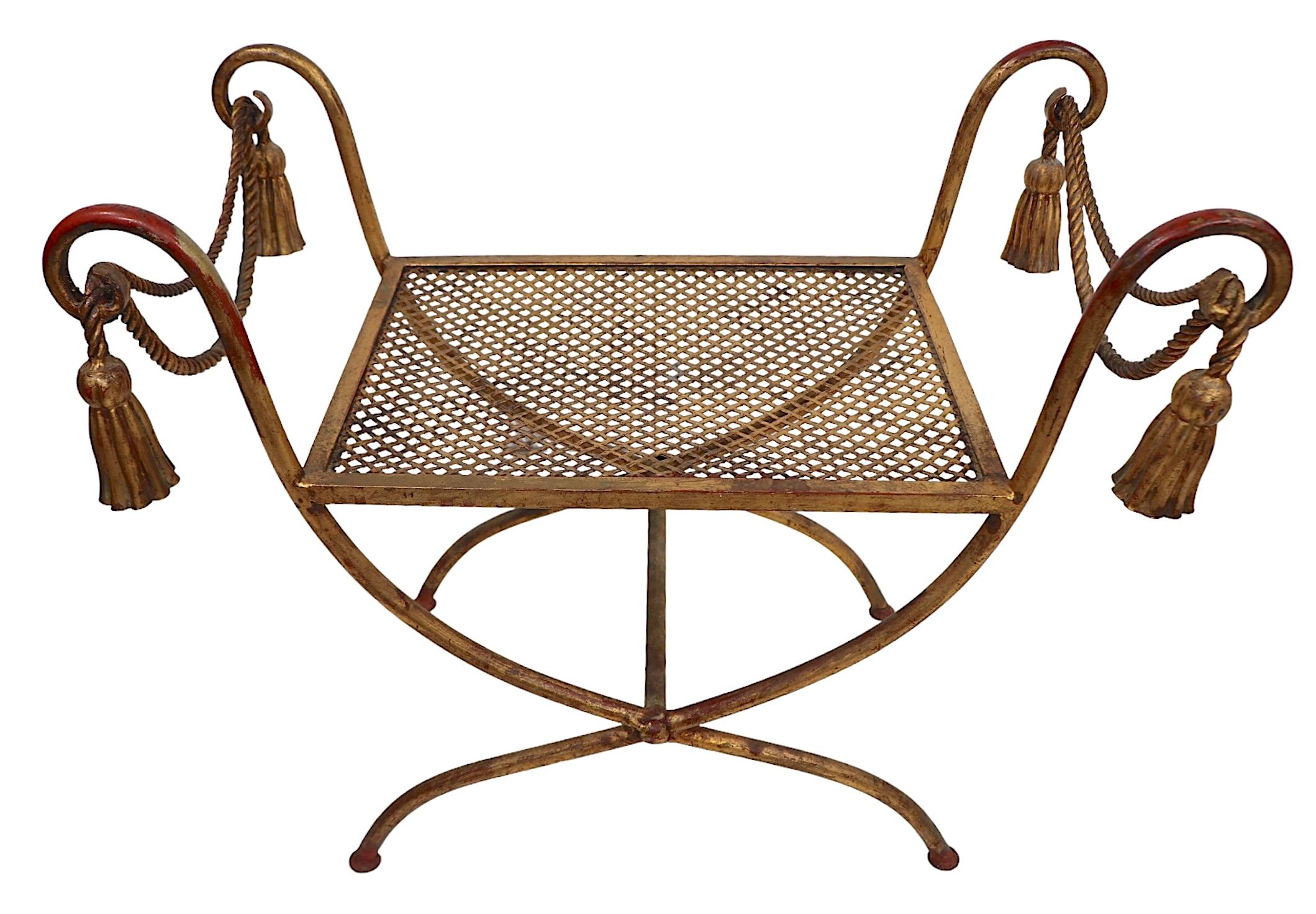 Vistoso banco de metal dorado de fabricación italiana con motivos de cuerdas y borlas. Este ejemplar está en muy buen estado, limpio y listo para usar. 
 Perfecto acento decorativo  banco, otomana o  puf, circa años 50/60. 
 Total H 24 x Asiento H