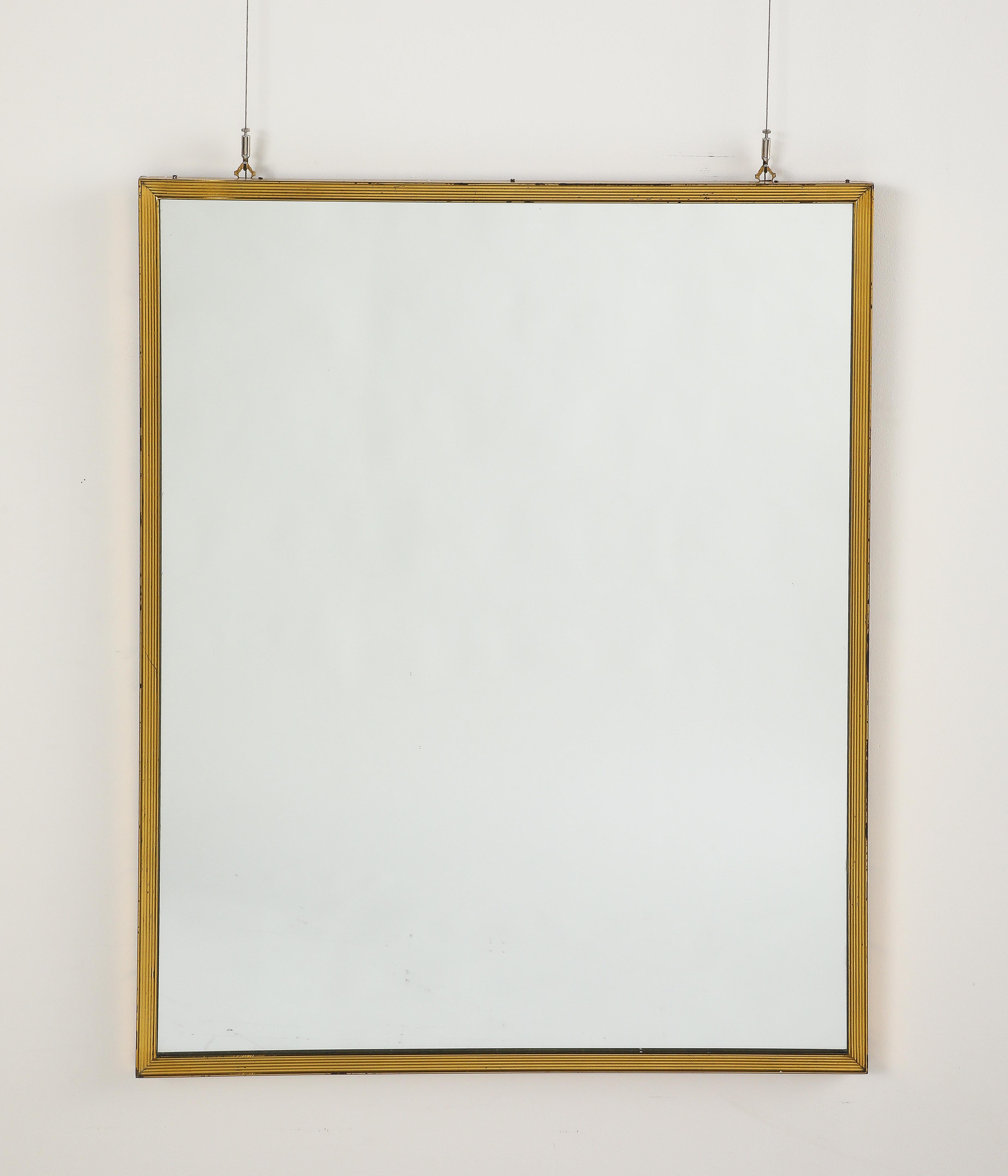 Specchio da parete rettangolare di grandi dimensioni in metallo dorato degli anni '70, con una cornice finemente rigata, con patina naturale e invecchiamento che contribuisce al suo fascino antico.
Italia, circa 1970 
Dimensioni: 40