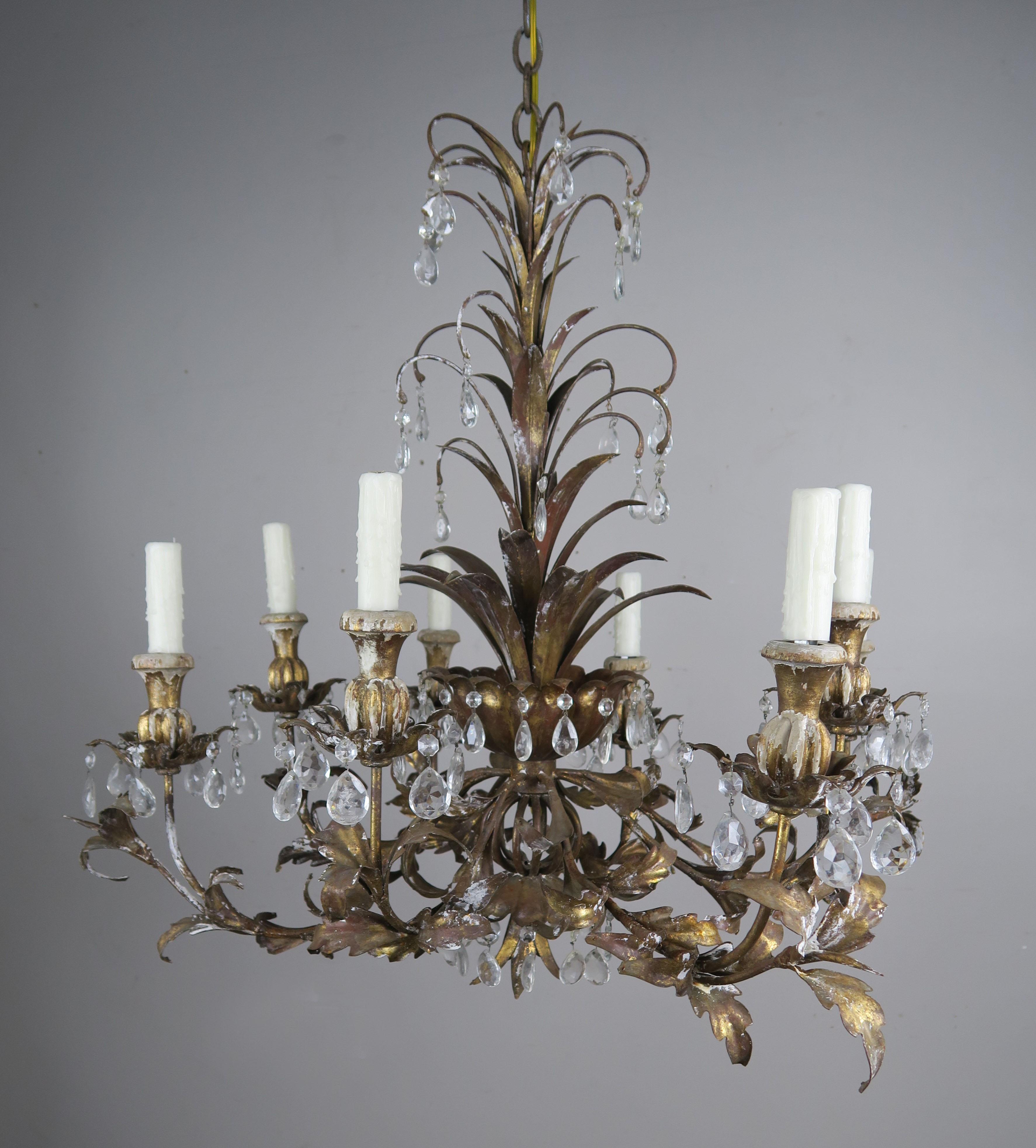 Italian gilt metal and wood (8) light chandelier adorned with almond shaped crystals throughout. The fixture has been newly rewired with cream colored drip wax candle covers. The fixture includes chain and canopy.