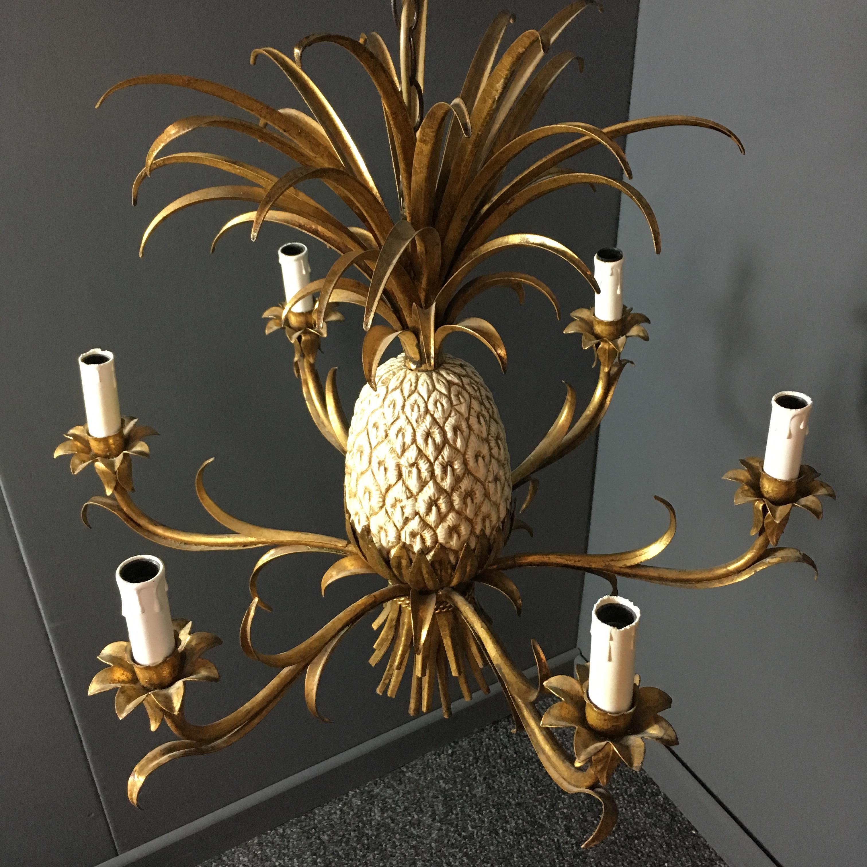 Stunning gilt tole chandelier with pineapple centre piece

Italian origin,

circa 1950s-1960s.

The central pineapple is metal and in cream color with highlights

The fronts are large and full

The light has six bulb holders

It is a