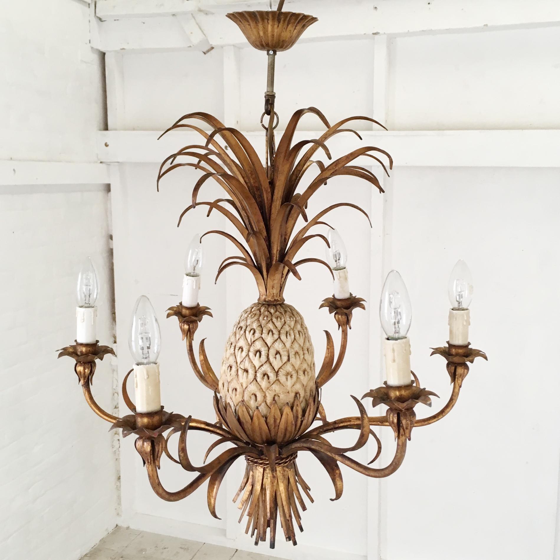 Stunning gilt tole chandelier with pineapple centre piece
Italian origin,
circa 1950s-1960s.
The central pineapple is metal and in cream color with highlights
The fronts are large and full
The light has six bulb holders
It is a large, beautifully