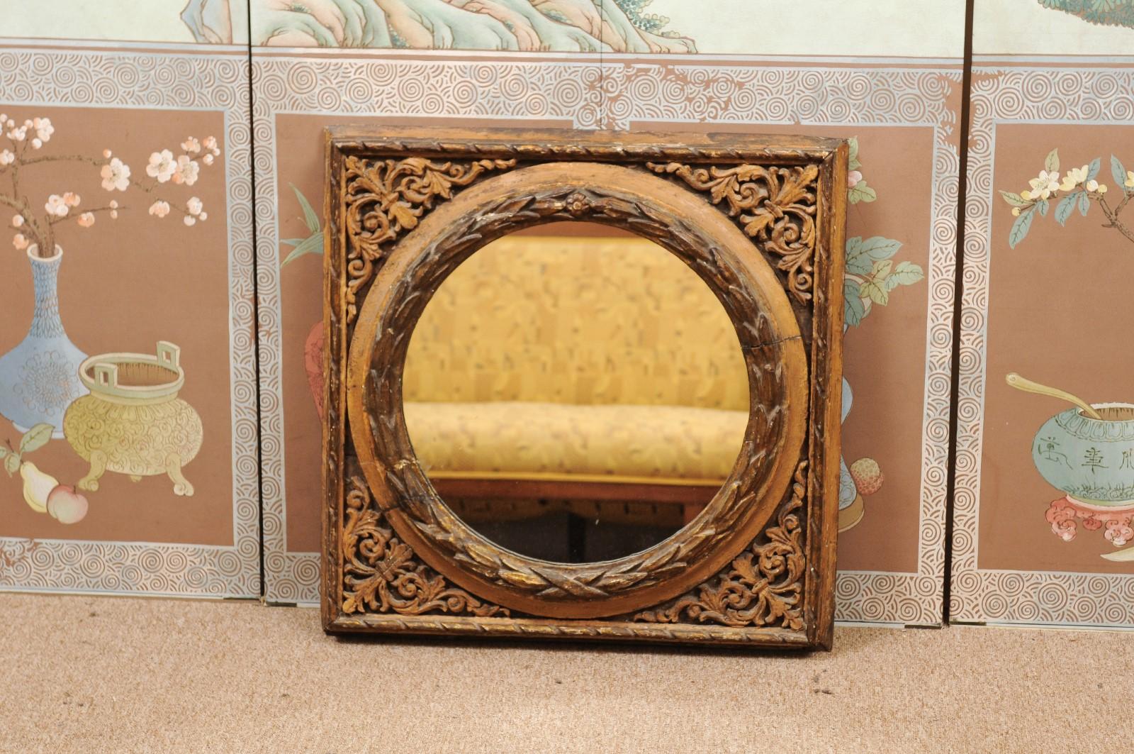 A 19th century Italian giltwood square frame featuring stylized acanthus leaf carving and laurel leaf carving boarding mirror plate.