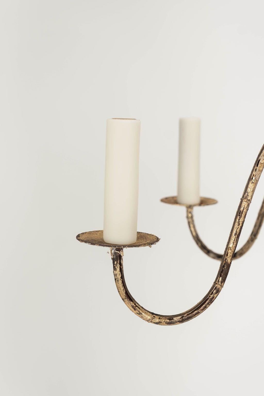 Italian giltwood and iron six-arm chandelier, newly created from 18th century and later elements. Turned water gilded body with six undulating iron arms decorated in remnants of gesso and gilding. Newly-wired for use within the USA. Six