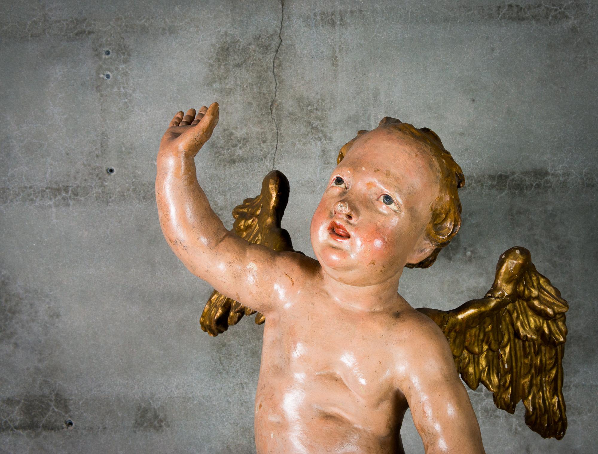 An Italian painted and giltwood cherub, from the 18th century.