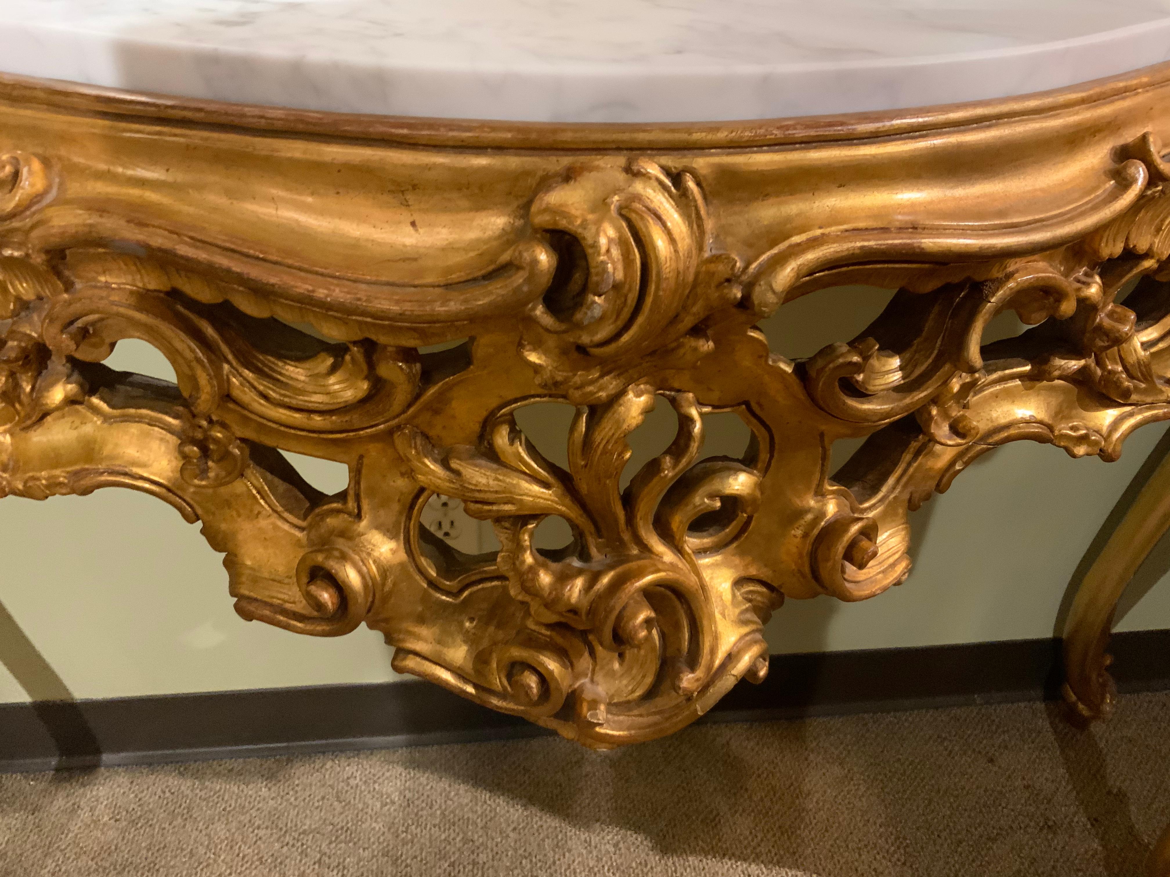 Exceptional gilding and carving on this console, the top with a conforming inset white marble,
The aprons are pierced and carved with scrolls and foliate motifs, raised on cabriole legs