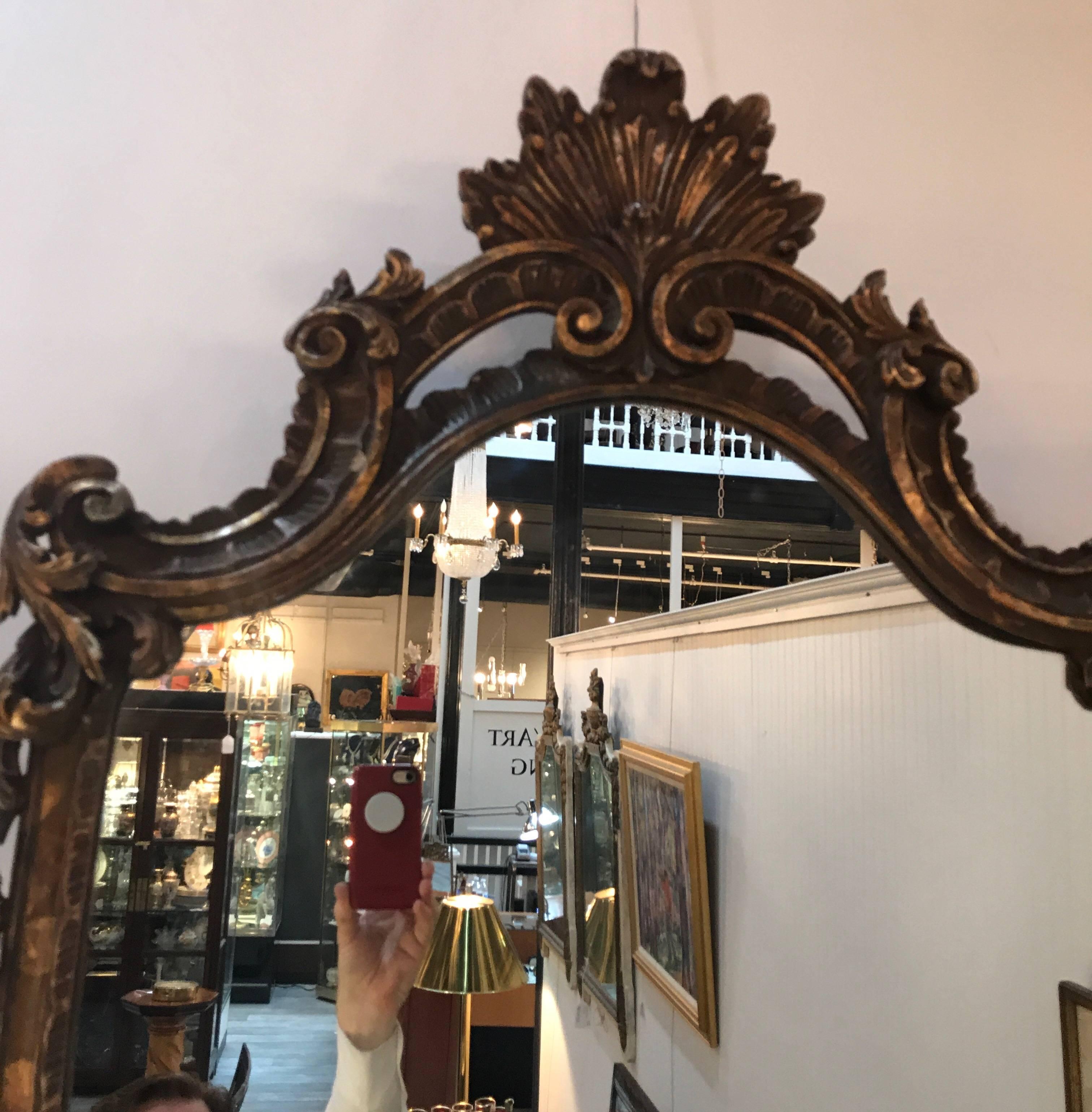 Italian giltwood mirror with pierced border frame. The gold is aged with a warm natural patination. The silvering on the mirror is clear.