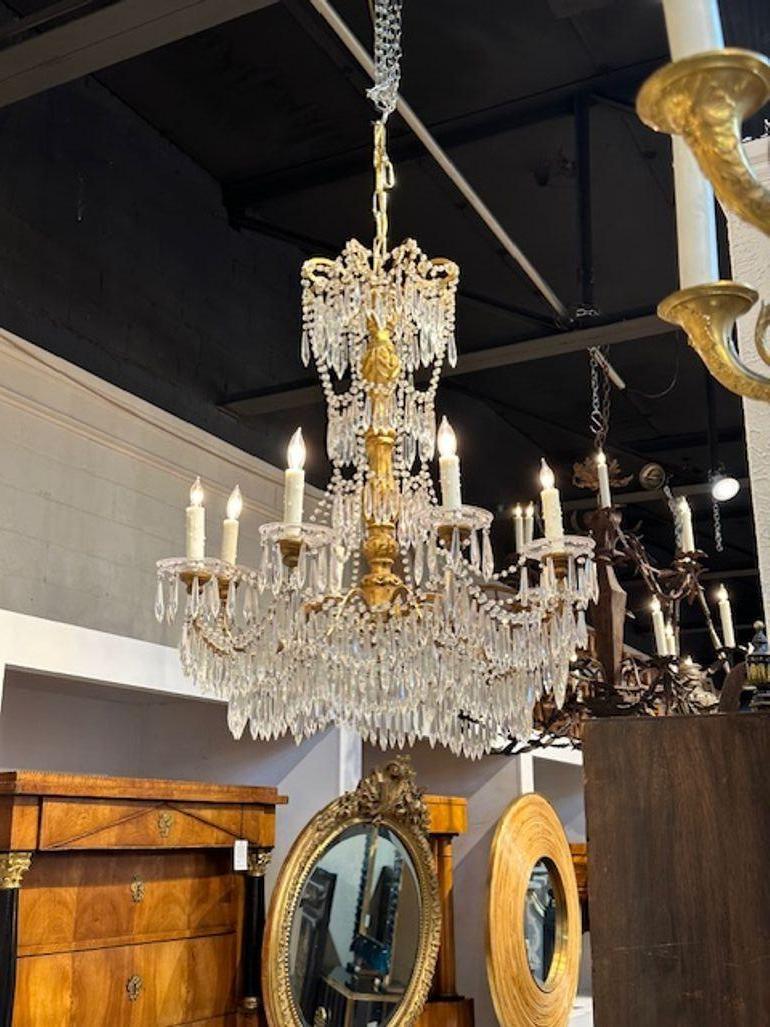 Lustre italien du XIXe siècle en bois doré et cristal de Gênes. Vers 1840. Le lustre a été recâblé par des professionnels et est livré avec une chaîne et un baldaquin assortis. Il est prêt à être suspendu !
