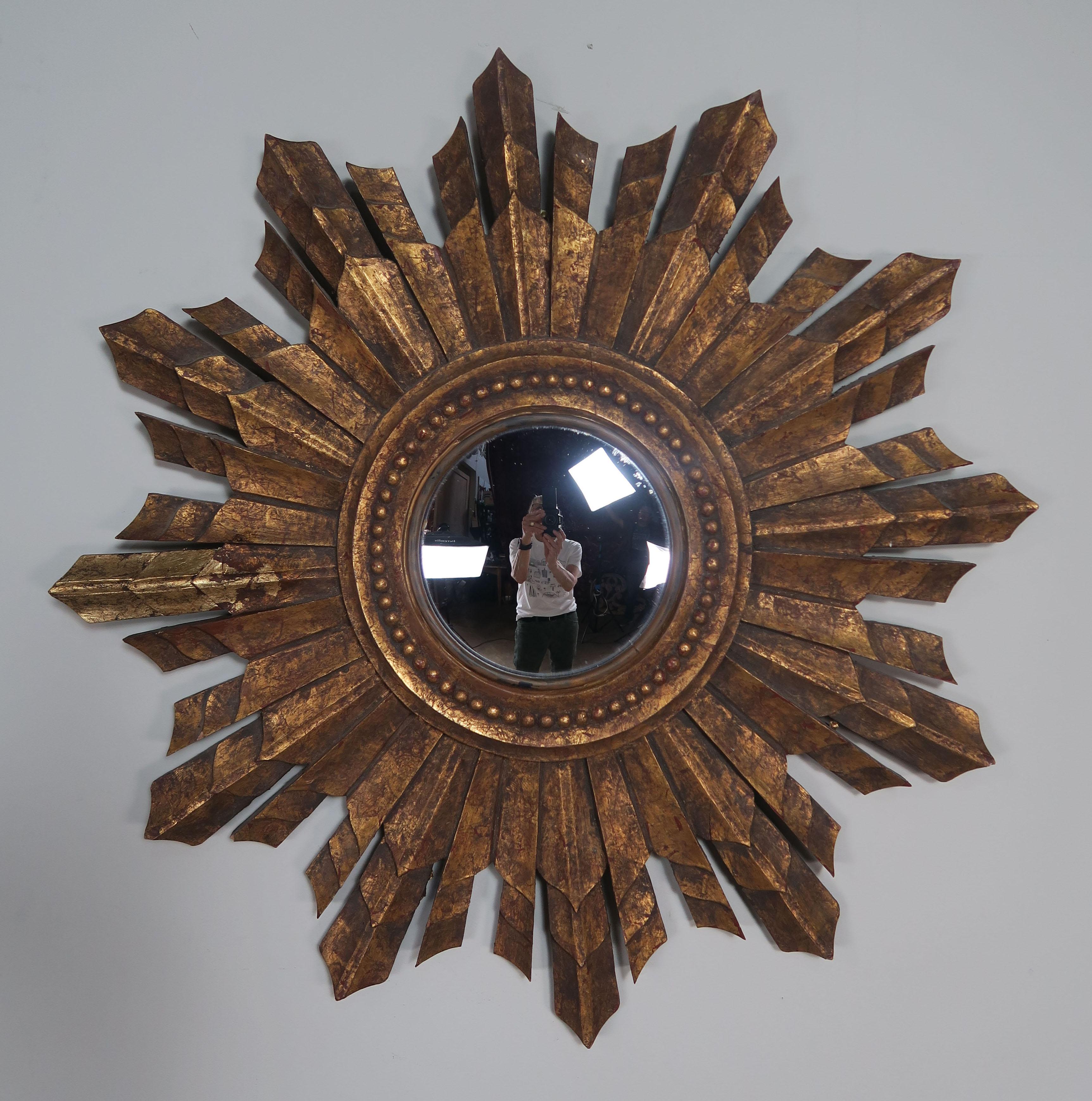 Italian carved giltwood convex sunburst mirror. The convex mirror, carved beaded detailing and varying sizes of rays makes this a beautiful example of the early to mid-20th century sunburst mirrors.