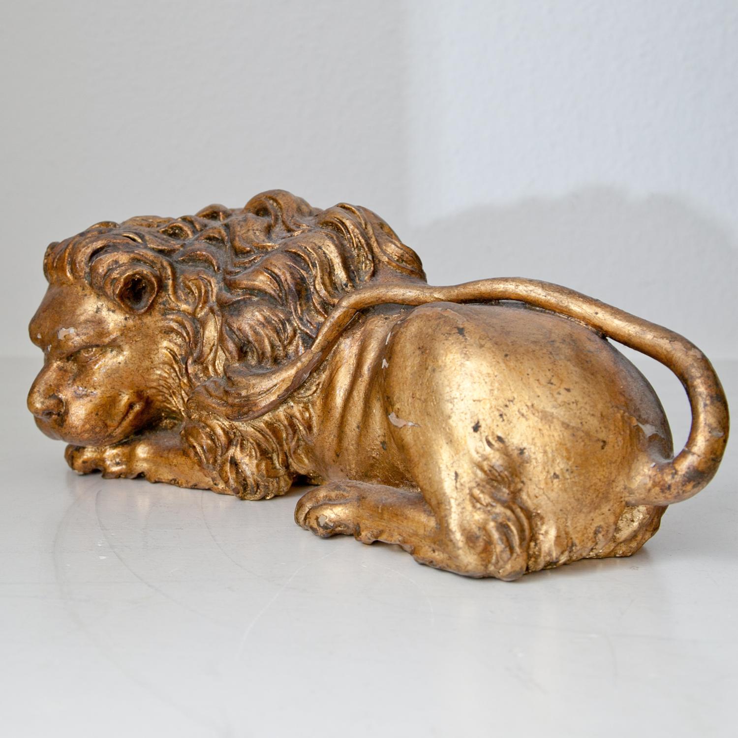 Italian carved giltwood lion in a lying posture, resting his head on his paws. Very finely detailed sculpture, the patina shows some smaller cracks.