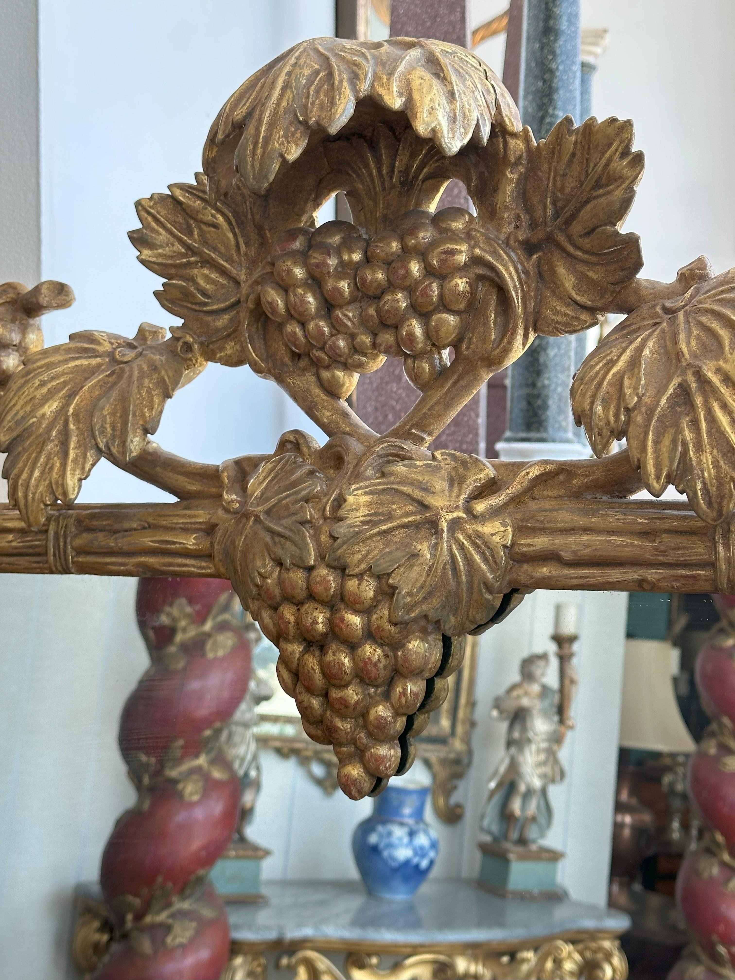 La plaque rectangulaire dans un cadre sculpté en bois doré incorporant des raisins et des feuilles.